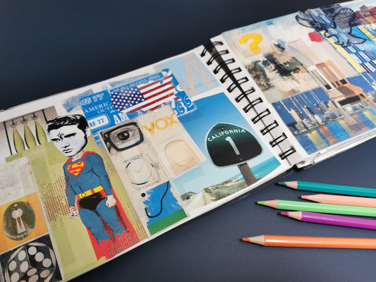 Open sketchbook with colourful stickers and pencils on a dark surface, pages from Victoria Mardon’s travels 2004/05