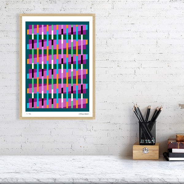 Colourful Lux Series abstract print by Victoria Mardon on a white brick wall, styled with creative studio supplies below.