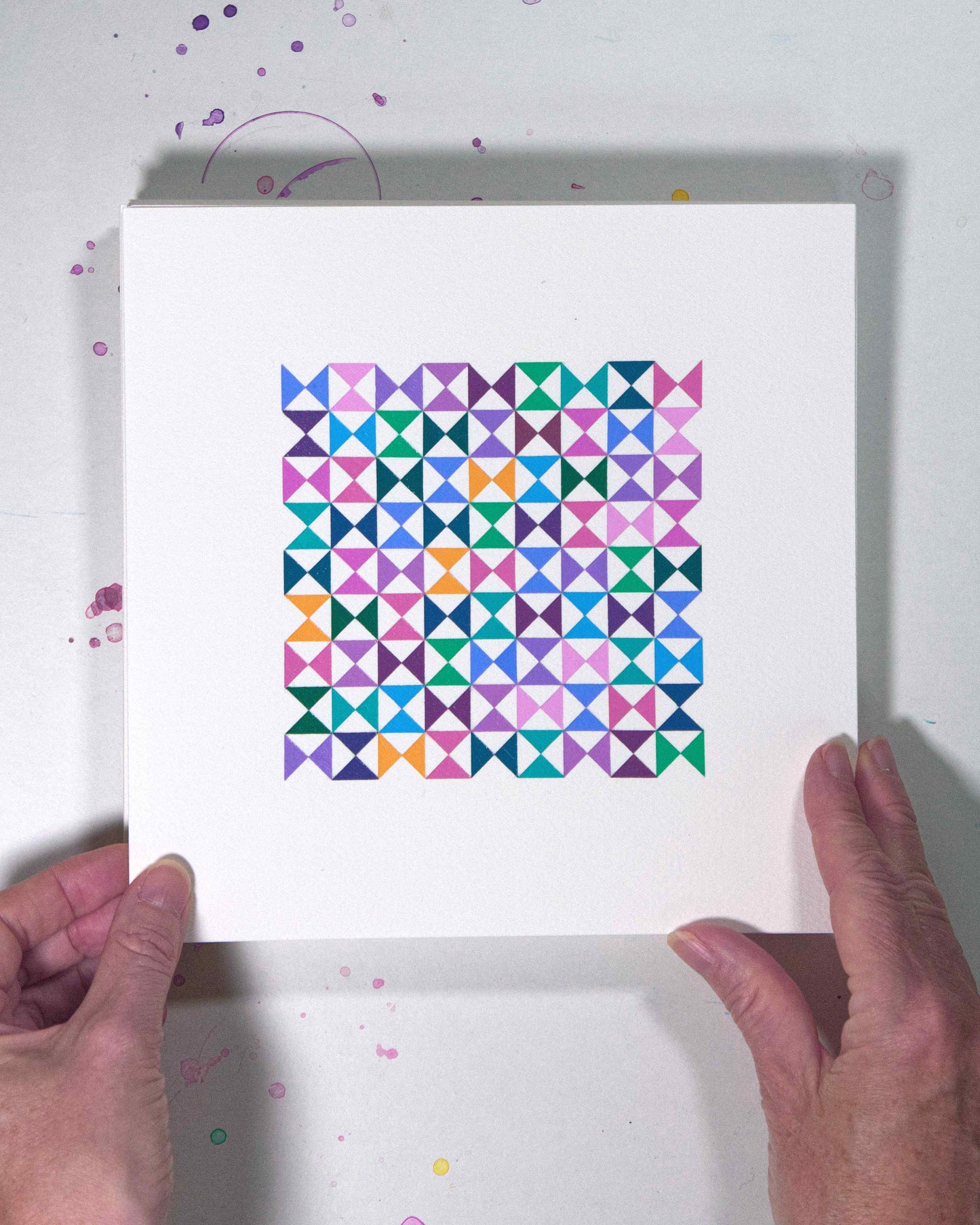 Hands holding a bold, graphic multicoloured abstract painting with repeating geometric shapes, 2 August – 033/365 (46236/365) by Victoria Mardon, 365: A Year in Colour series.