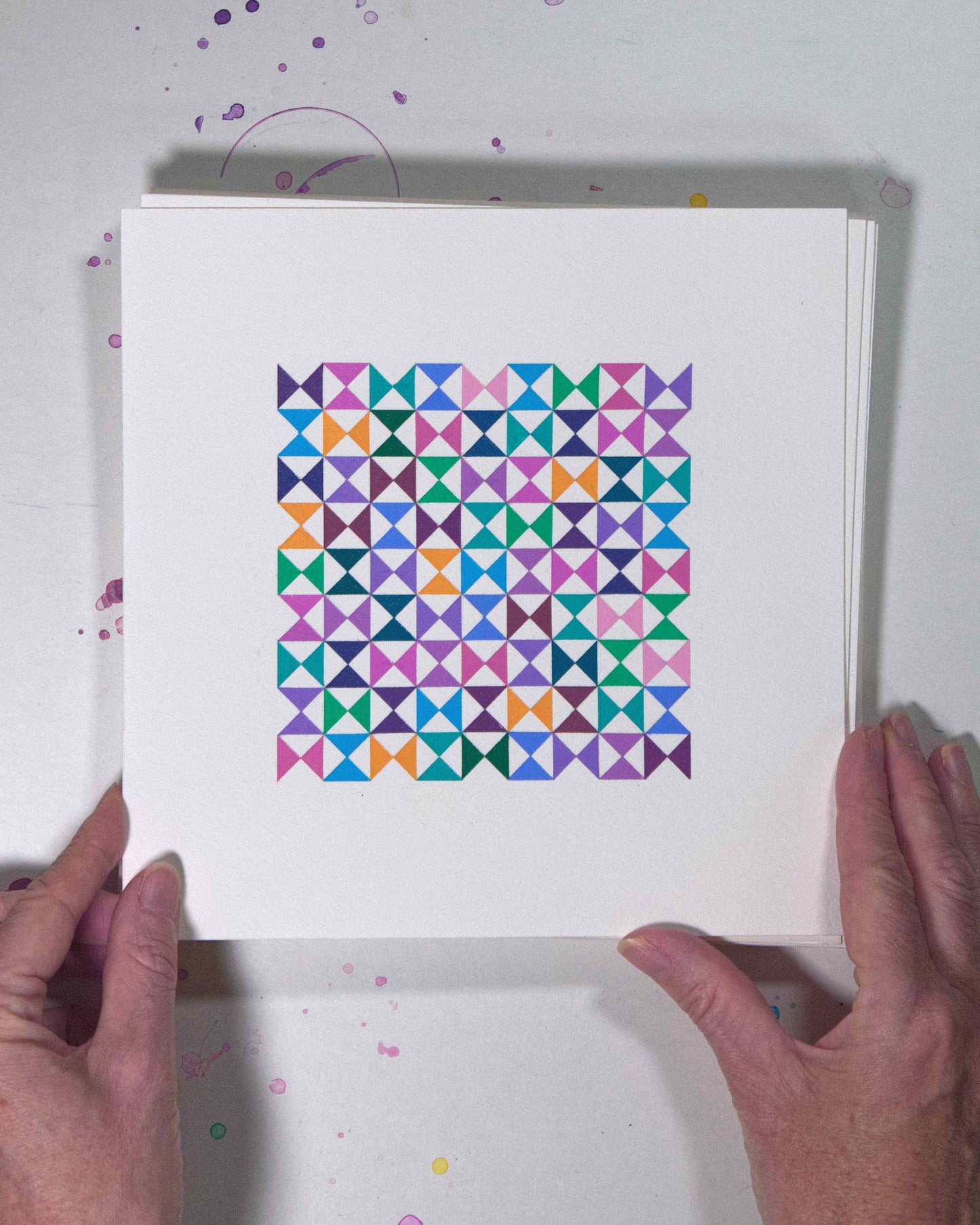 Hands holding a bold, graphic multicoloured abstract painting with repeating geometric shapes, 9 July – 009/365 (46212/365) by Victoria Mardon, 365: A Year in Colour series.