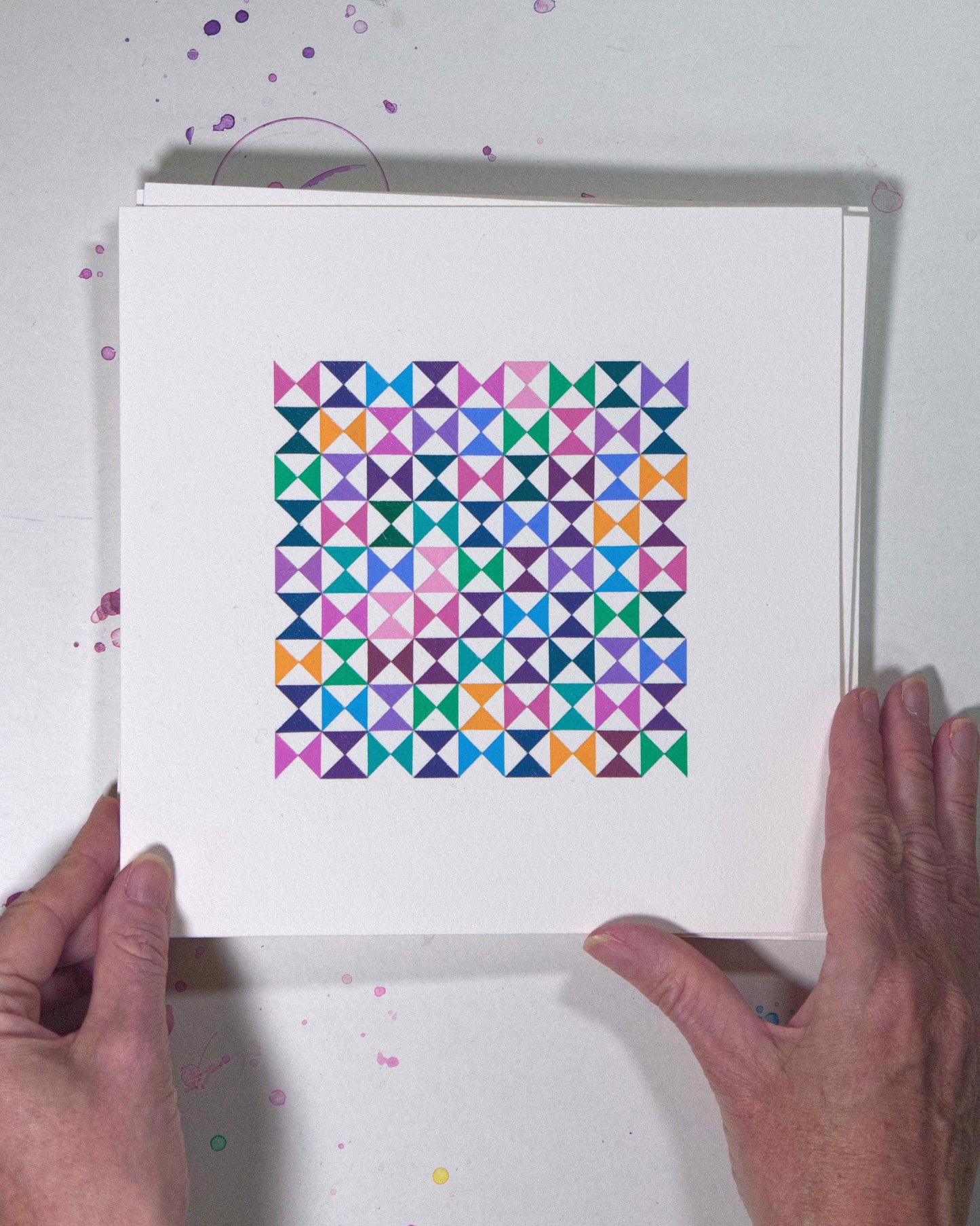 Hands holding a bold, graphic multicoloured abstract painting with repeating geometric shapes, 14 July – 014/365 (46217/365) by Victoria Mardon, 365: A Year in Colour series.