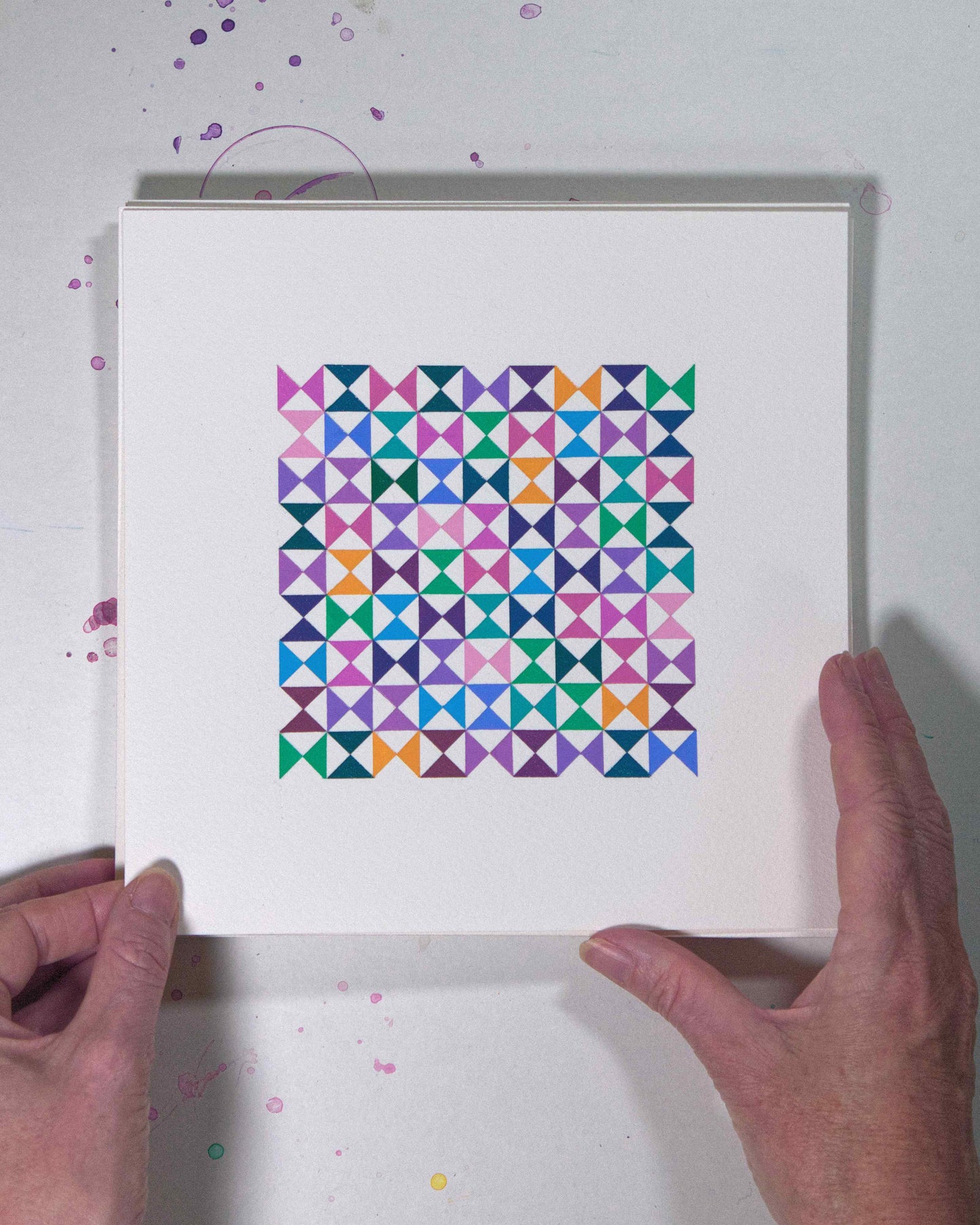 Hands holding a bold, graphic multicoloured abstract painting with repeating geometric shapes, 15 July – 015/365 (46218/365) by Victoria Mardon, 365: A Year in Colour series.