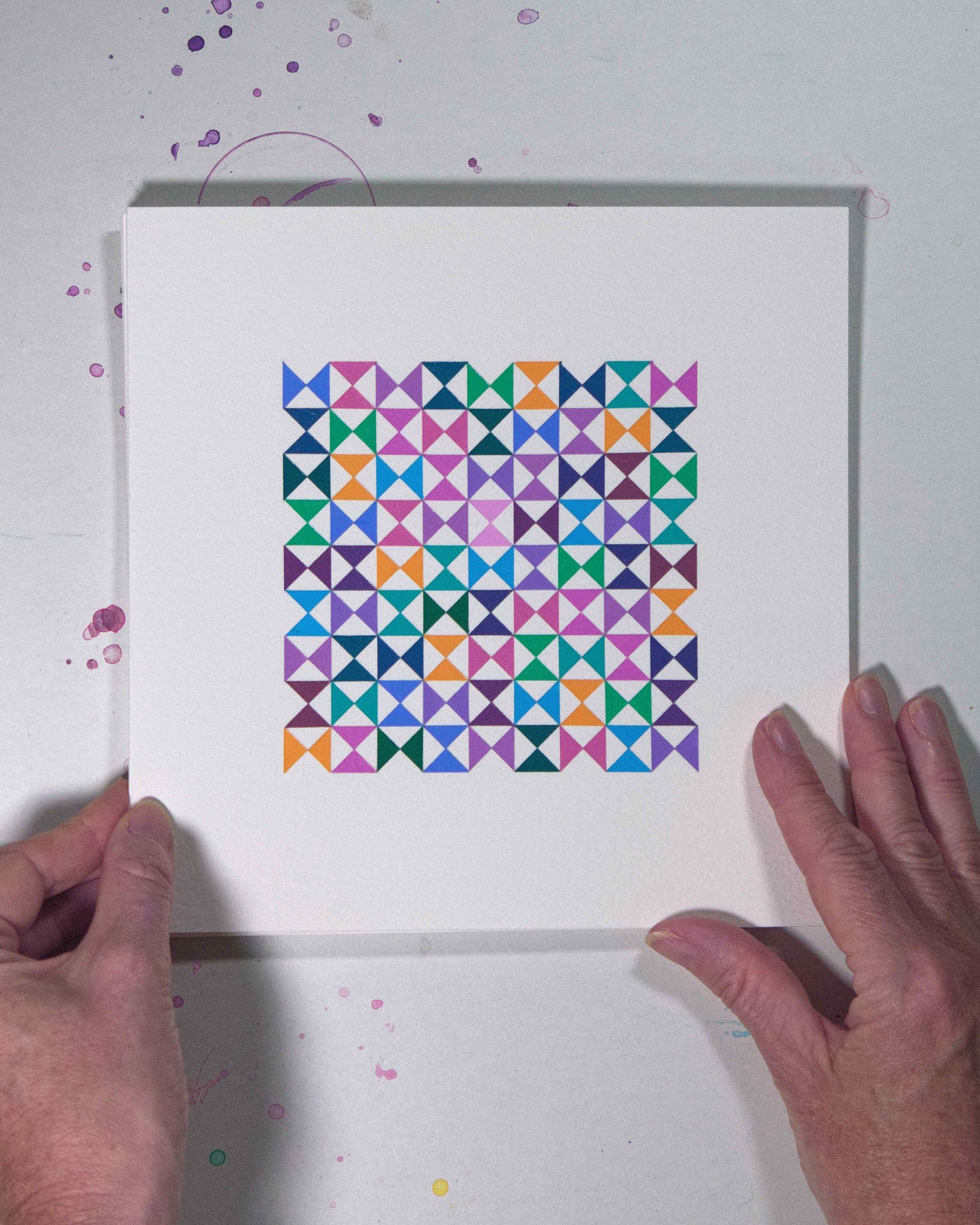 Hands holding a bold, graphic multicoloured abstract painting with repeating geometric shapes, 23 August – 054/365 (46257/365) by Victoria Mardon, 365: A Year in Colour series.