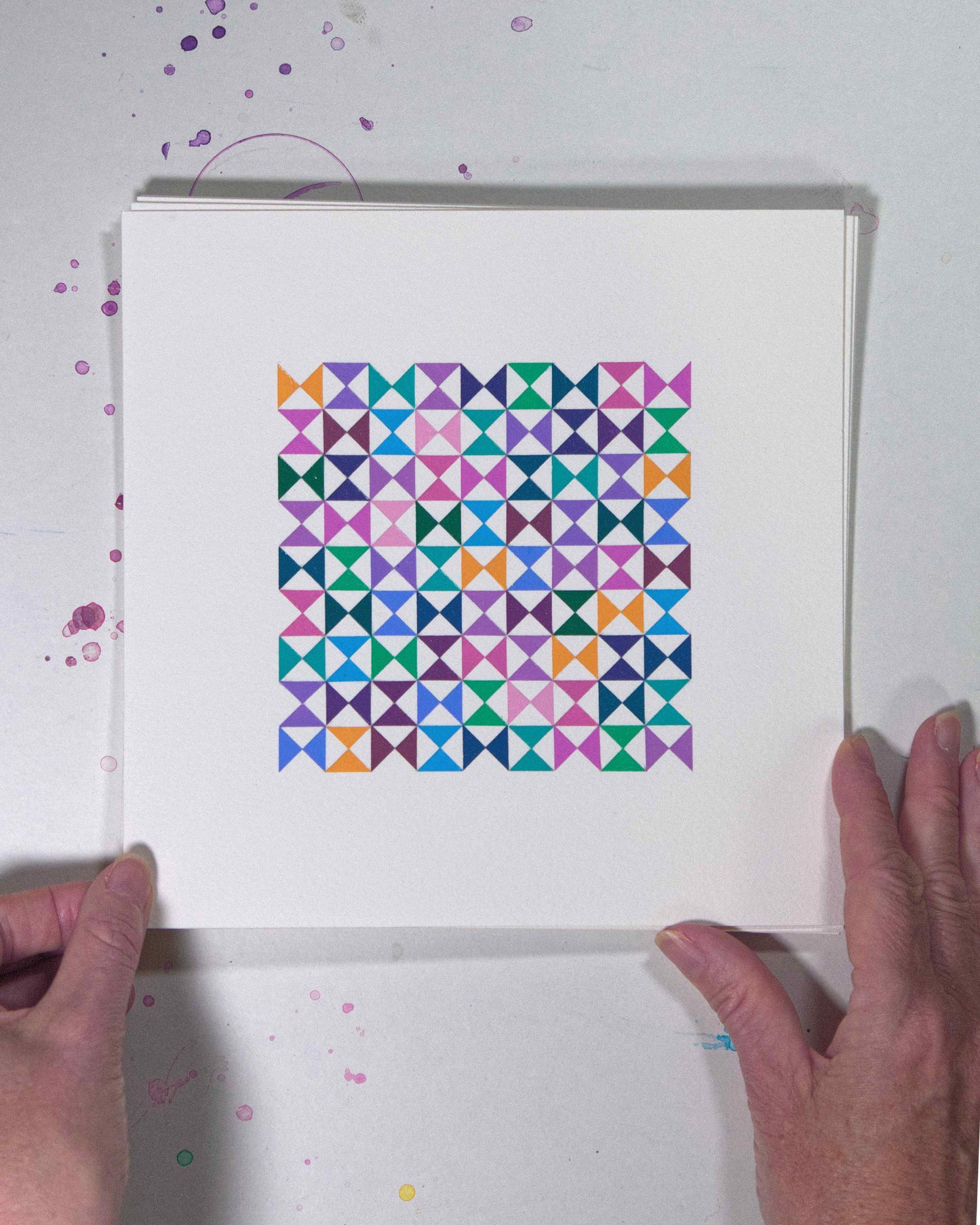 Hands holding a bold, graphic multicoloured abstract painting with repeating geometric shapes, 25 July – 025/365 (46228/365) by Victoria Mardon, 365: A Year in Colour series.