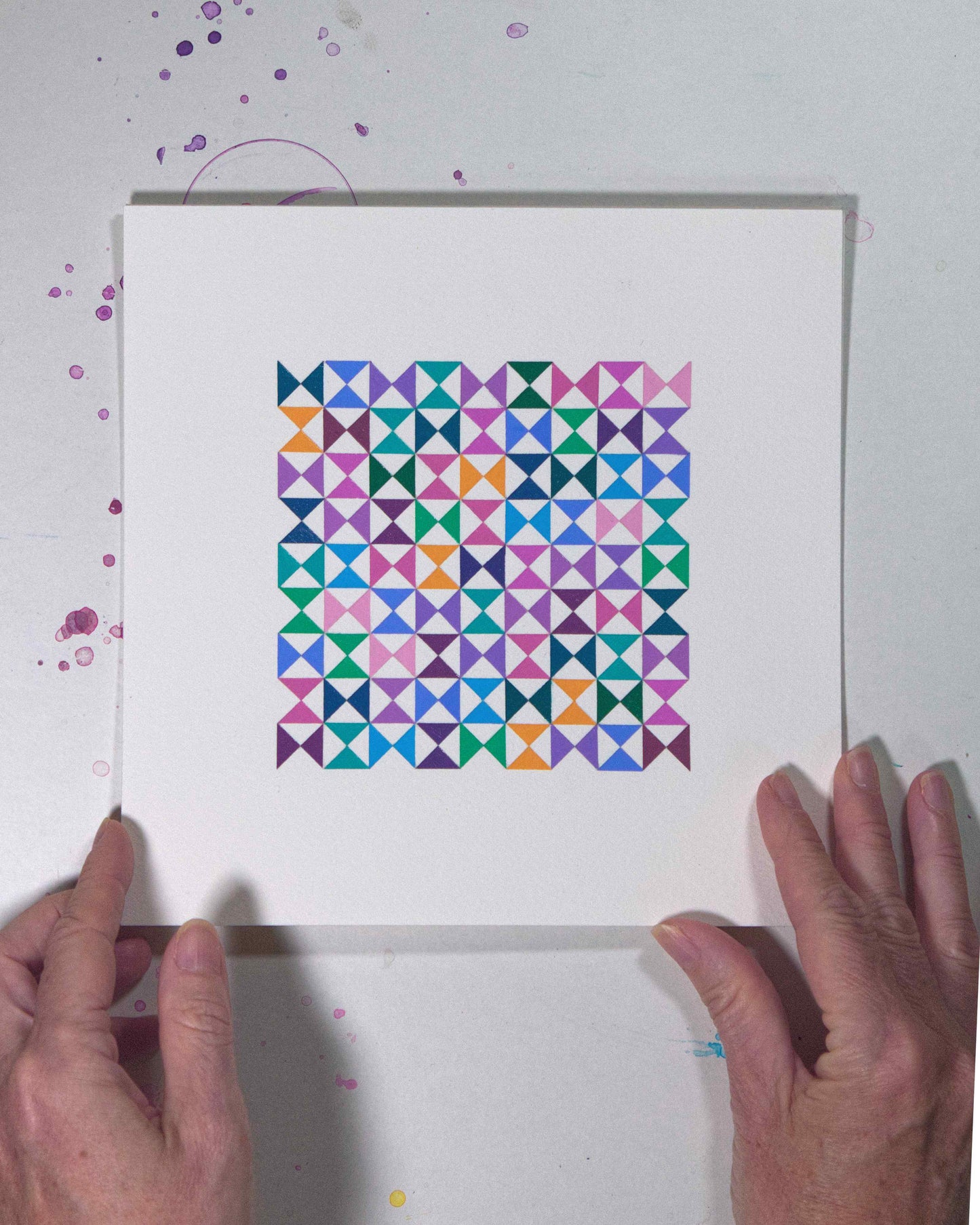 Hands holding a bold, graphic multicoloured abstract painting with repeating geometric shapes, 29 July – 029/365 by Victoria Mardon, 365: A Year in Colour series.