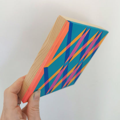 Hand holding “B PG7/PB15:3 – PB15:3/PG7” – a small 15 x 15 cm canvas with a colourful geometric pattern. Part of Victoria Mardon’s B.E.L.O.N.G.I.N.G series, shown for scale.