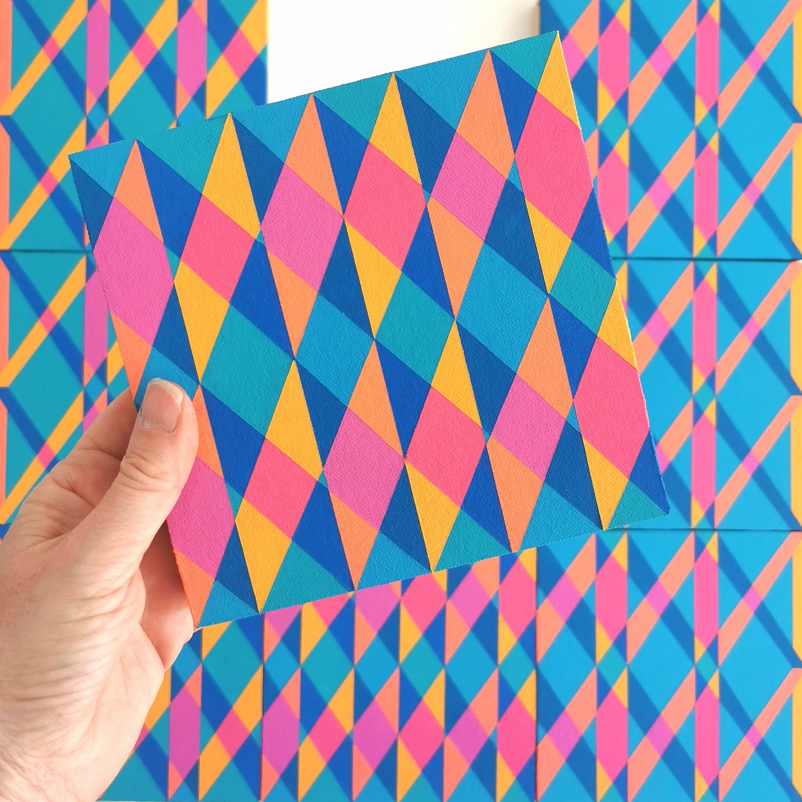 “E PG7/PB15:3 – PB15:3/PG7” – one module from Victoria Mardon’s B.E.L.O.N.G.I.N.G series held in front of the full artwork. Colourful geometric pattern on canvas, shown in context.
