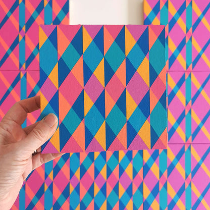 “E PV19 PR122” – one module from Victoria Mardon’s B.E.L.O.N.G.I.N.G series held in front of the full artwork. Colourful geometric pattern on canvas, shown in context.