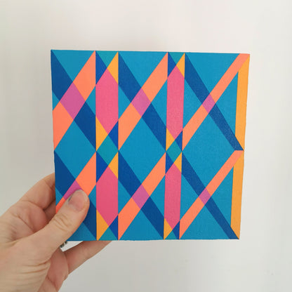 Hand holding “G1 PG7/PB15:3 – PB15:3/PG7” – a small 15 x 15 cm canvas with a colourful geometric pattern. Part of Victoria Mardon’s B.E.L.O.N.G.I.N.G series, shown for scale.