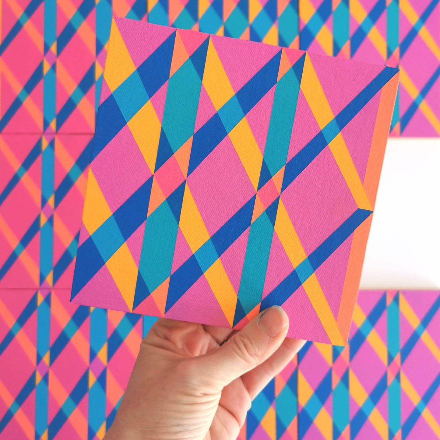 “G1 PV19 PR122” – one module from Victoria Mardon’s B.E.L.O.N.G.I.N.G series held in front of the full artwork. Colourful geometric pattern on canvas, shown in context.