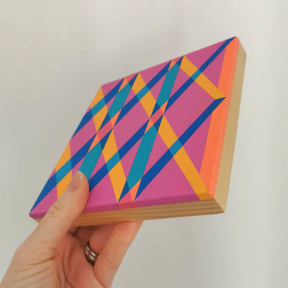 Hand holding “G1 PV19 PR122” – a small 15 x 15 cm canvas with a colourful geometric pattern. Part of Victoria Mardon’s B.E.L.O.N.G.I.N.G series, shown for scale.