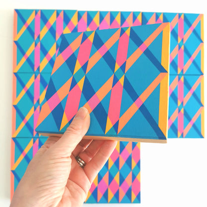 “G2 PG7/PB15:3 – PB15:3/PG7” – one module from Victoria Mardon’s B.E.L.O.N.G.I.N.G series held in front of the full artwork. Colourful geometric pattern on canvas, shown in context.