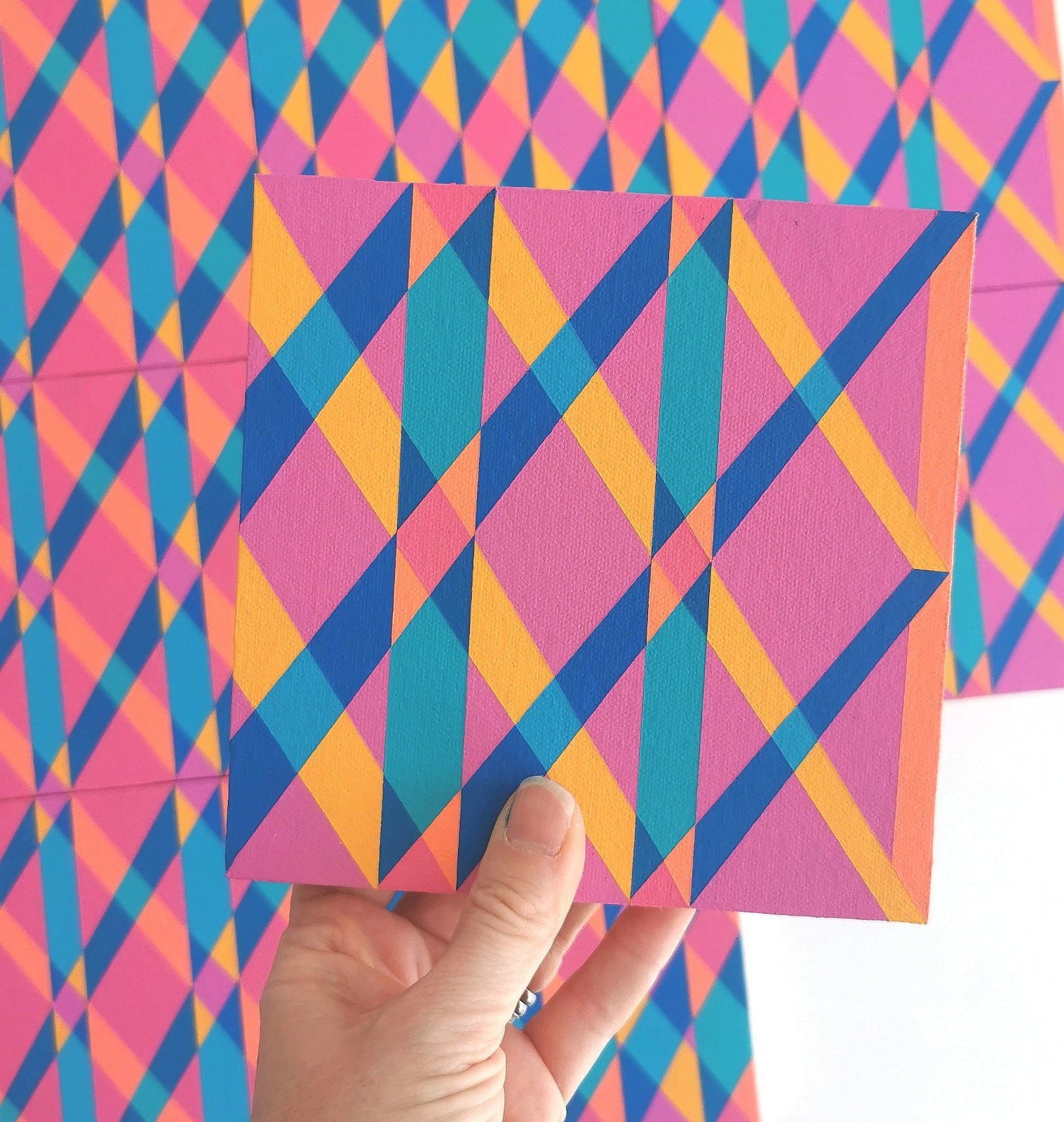 “G2 PV19 PR122” – one module from Victoria Mardon’s B.E.L.O.N.G.I.N.G series held in front of the full artwork. Colourful geometric pattern on canvas, shown in context.
