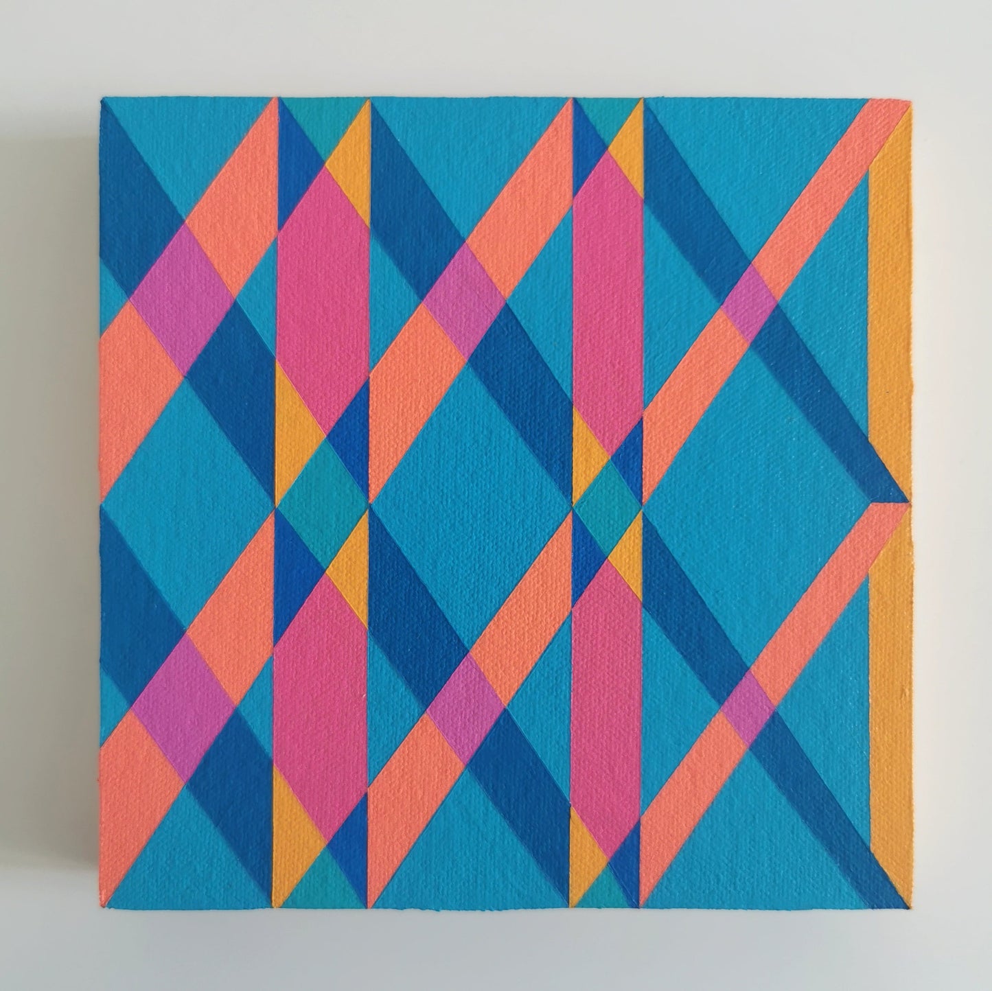 “L PG7/PB15:3 – PB15:3/PG7” – small abstract canvas painting with a geometric pattern in blue, pink and orange on a white background. Part of the B.E.L.O.N.G.I.N.G modular series by Victoria Mardon.