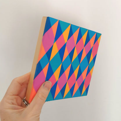 Hand holding “N1 PG7/PB15:3 – PB15:3/PG7” – a small 15 x 15 cm canvas with a colourful geometric pattern. Part of Victoria Mardon’s B.E.L.O.N.G.I.N.G series, shown for scale.