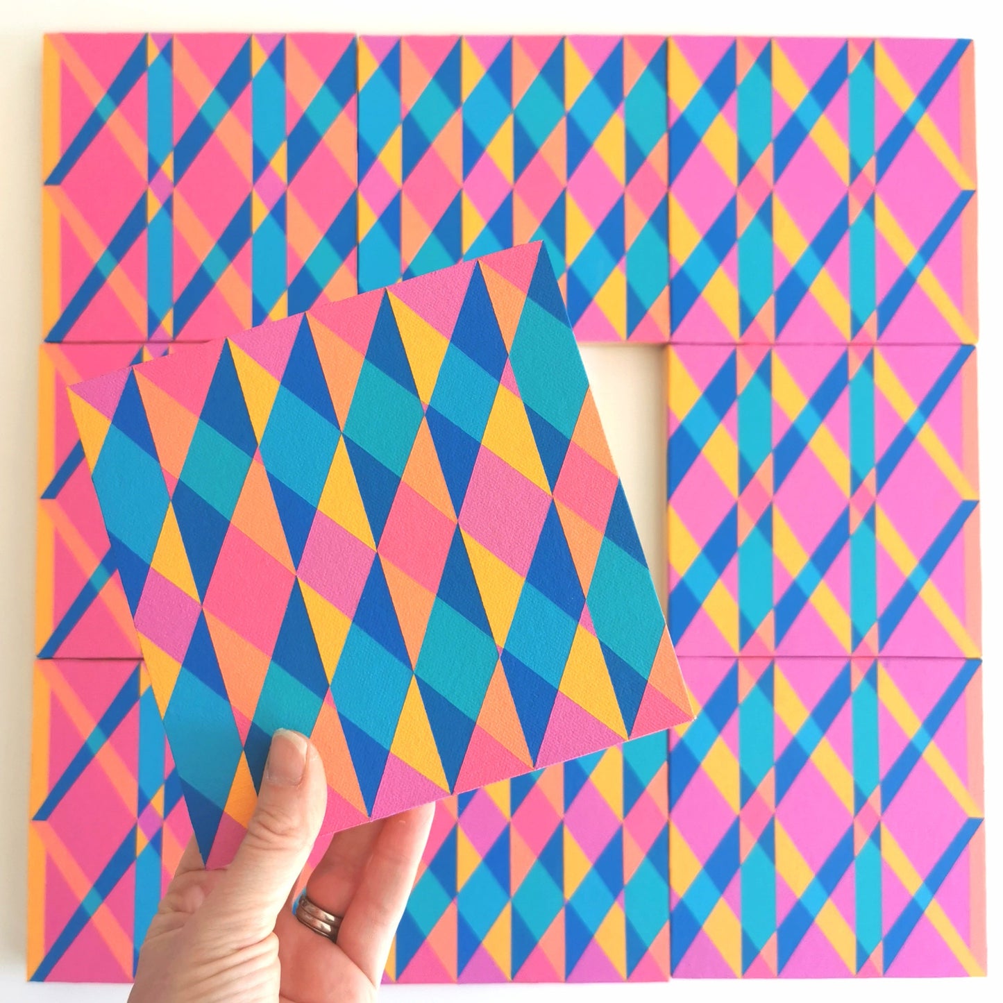 “N1 PV19 PR122” – one module from Victoria Mardon’s B.E.L.O.N.G.I.N.G series held in front of the full artwork. Colourful geometric pattern on canvas, shown in context.