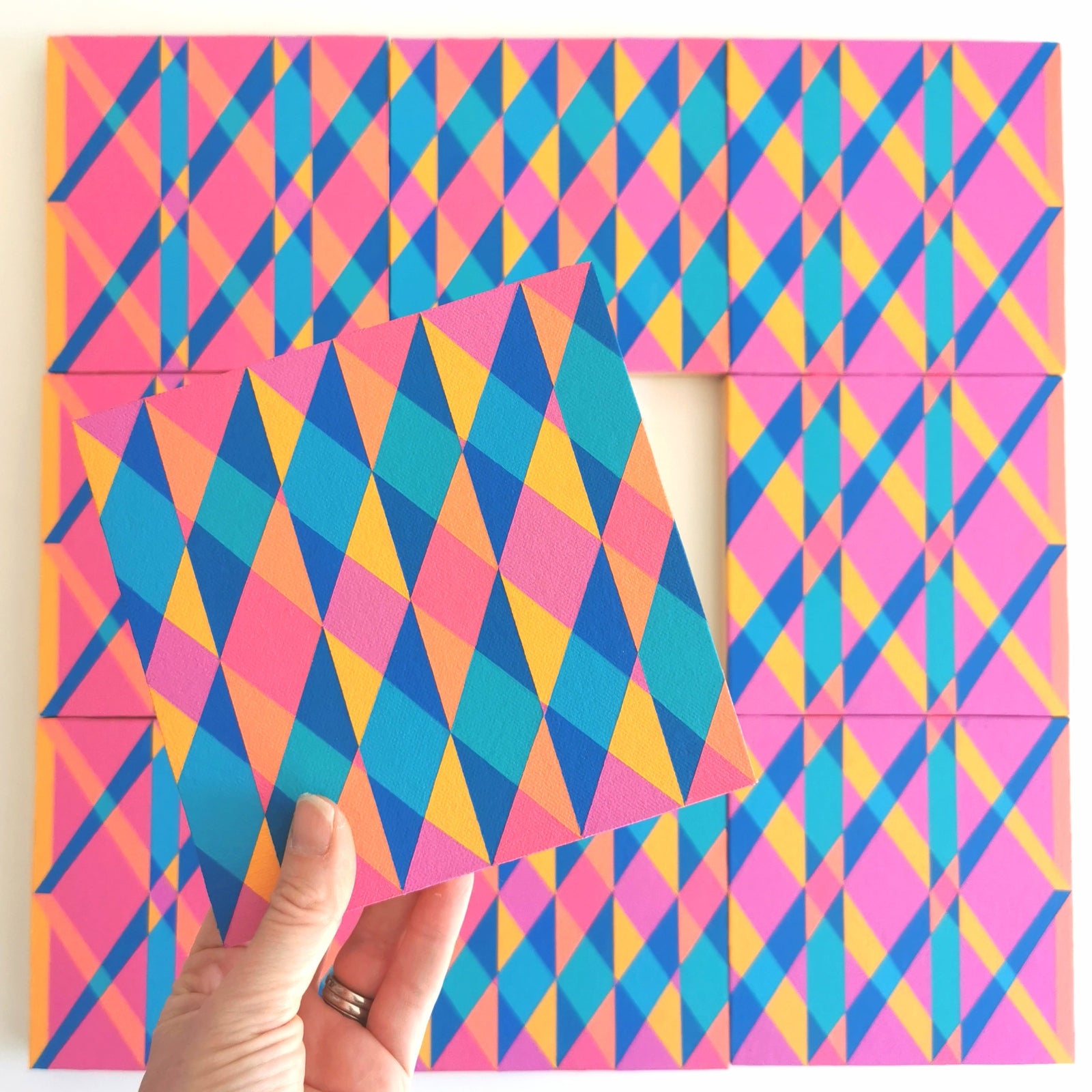 “N1 PV19 PR122” – one module from Victoria Mardon’s B.E.L.O.N.G.I.N.G series held in front of the full artwork. Colourful geometric pattern on canvas, shown in context.