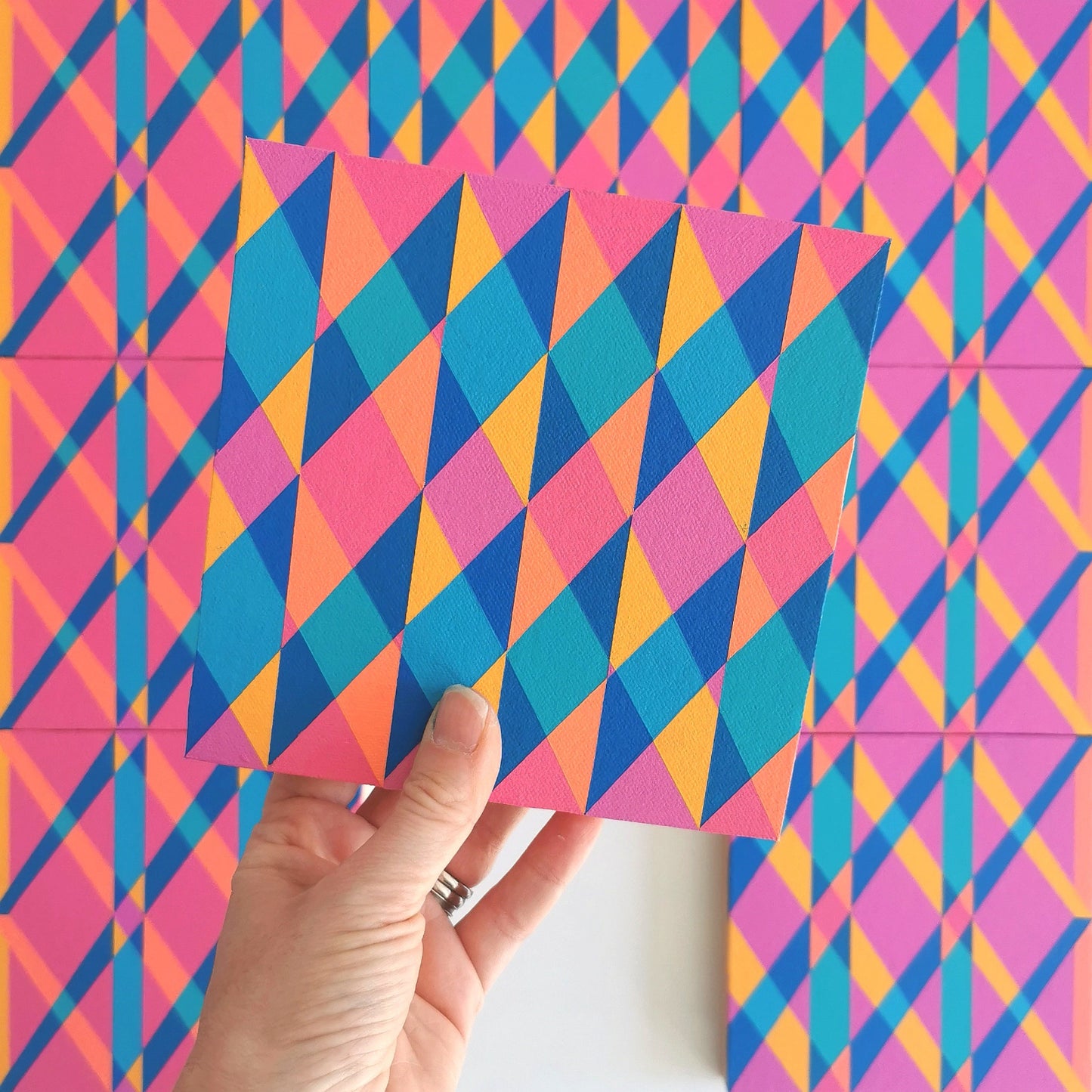 “N2 PV19 PR122” – one module from Victoria Mardon’s B.E.L.O.N.G.I.N.G series held in front of the full artwork. Colourful geometric pattern on canvas, shown in context.