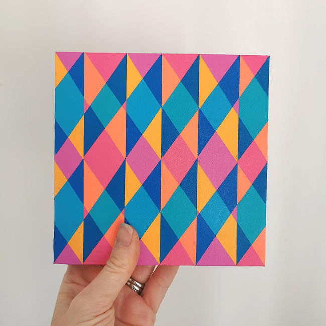 Hand holding “N2 PV19 PR122” – a small 15 x 15 cm canvas with a colourful geometric pattern. Part of Victoria Mardon’s B.E.L.O.N.G.I.N.G series, shown for scale.