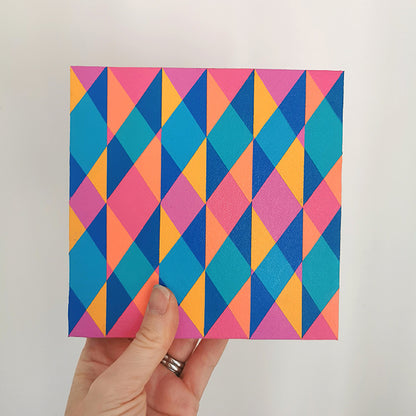 Hand holding “N2 PV19 PR122” – a small 15 x 15 cm canvas with a colourful geometric pattern. Part of Victoria Mardon’s B.E.L.O.N.G.I.N.G series, shown for scale.