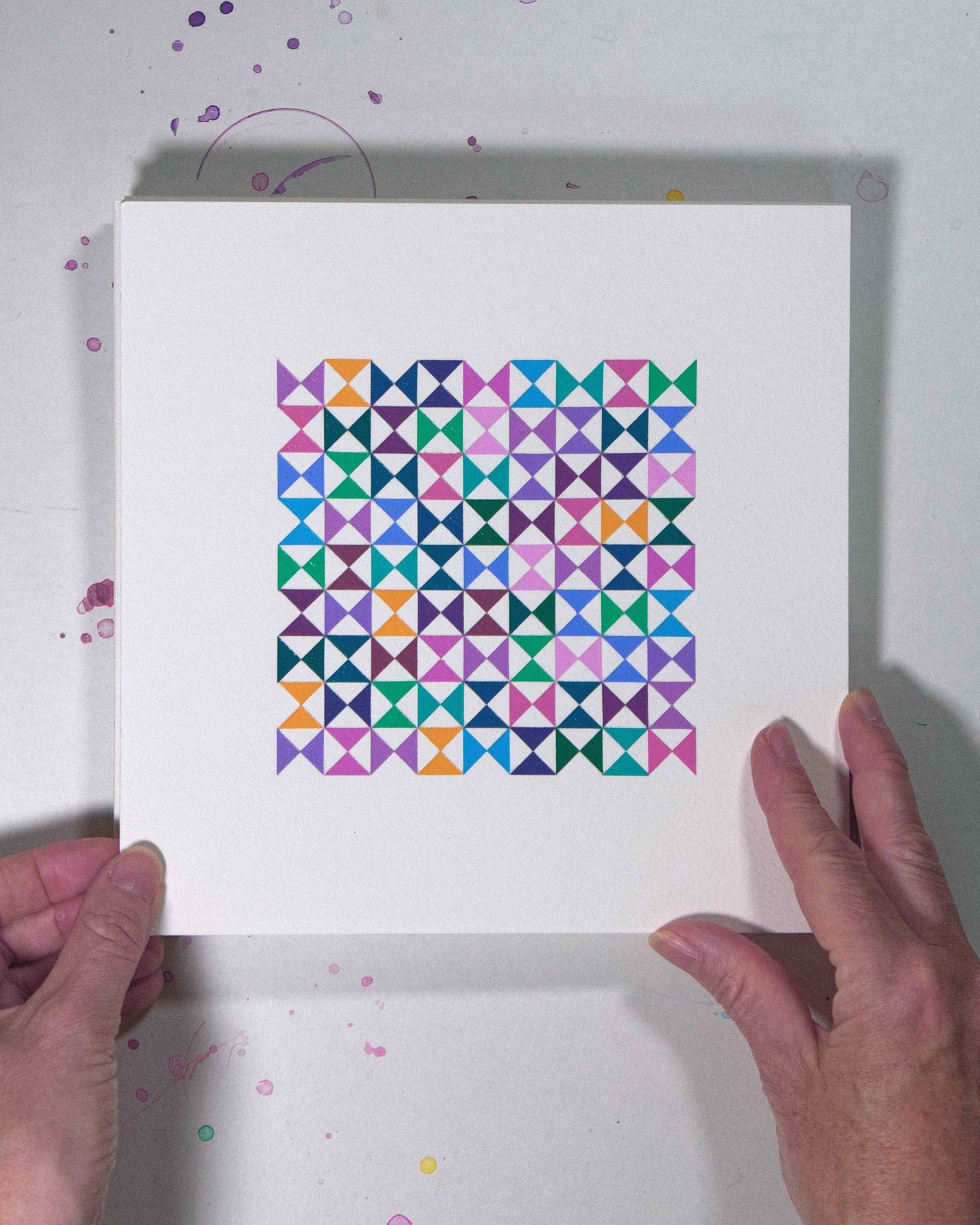 Hands holding a bold, graphic multicoloured abstract painting with repeating geometric shapes, 3 August – 034/365 (46237/365) by Victoria Mardon, 365: A Year in Colour series.