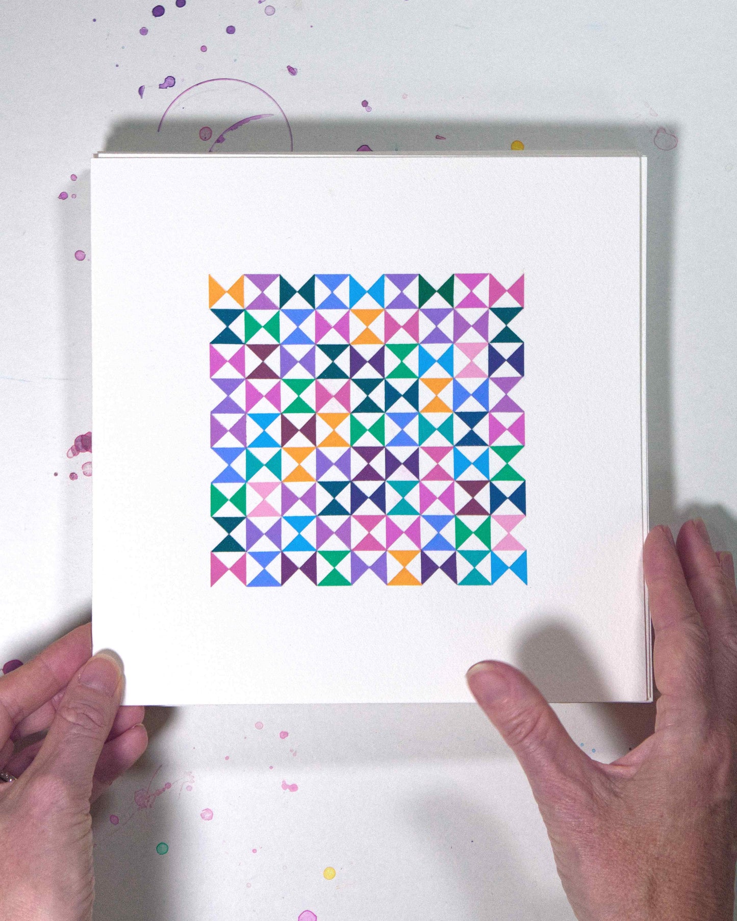 Hands holding a bold, graphic multicoloured abstract painting with repeating geometric shapes, 3 July – 003/365 (46206/365) by Victoria Mardon, 365: A Year in Colour series.