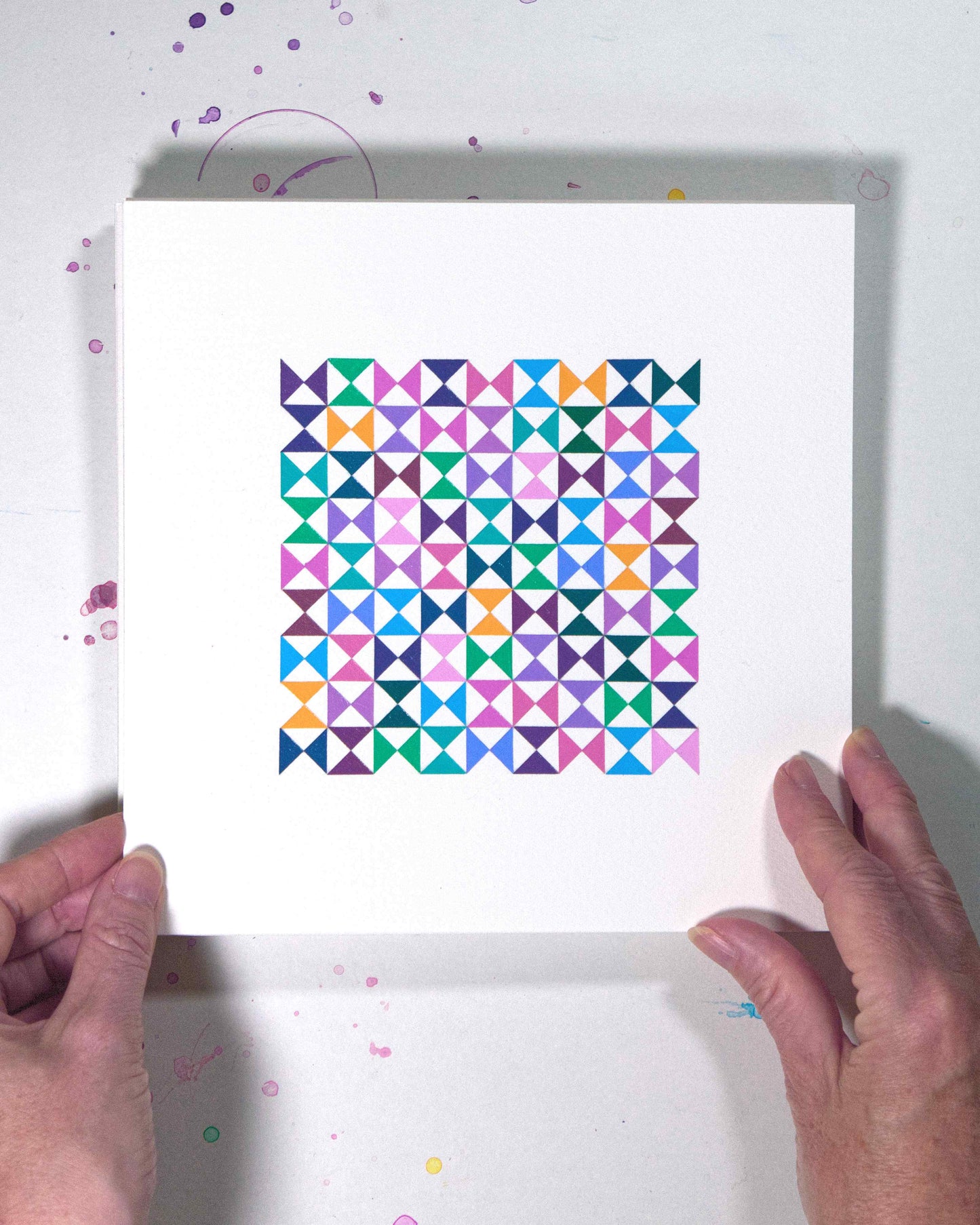 Hands holding a bold, graphic multicoloured abstract painting with repeating geometric shapes, 4 August – 035/365 (46238/365) by Victoria Mardon, 365: A Year in Colour series.