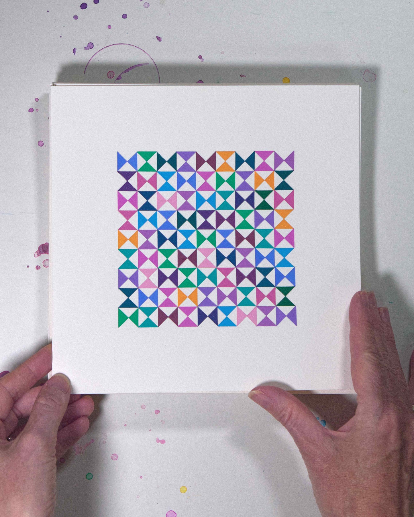 Hands holding a bold, graphic multicoloured abstract painting with repeating geometric shapes, 4 July – 004/365 (46207/365) by Victoria Mardon, 365: A Year in Colour series.