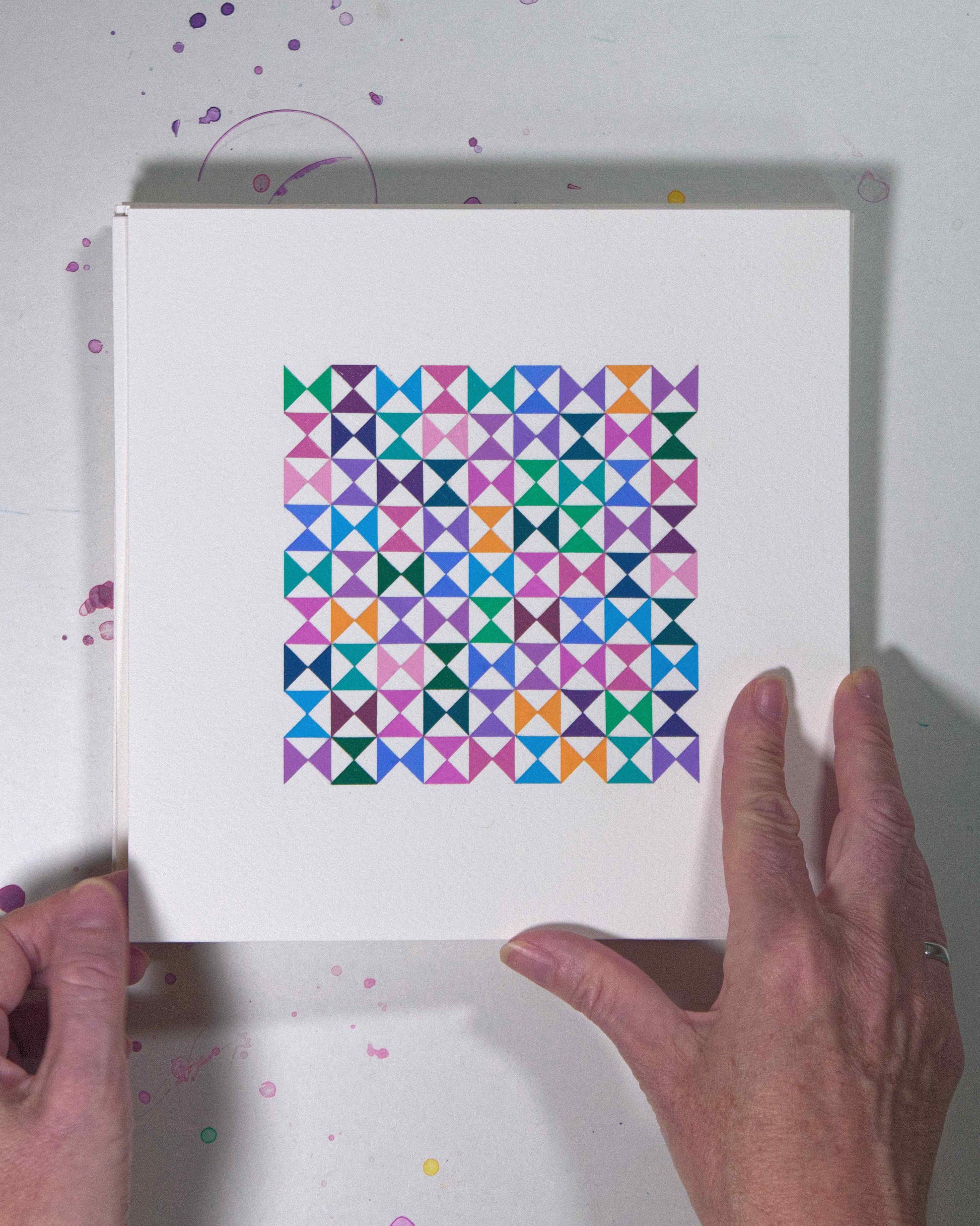 Hands holding a bold, graphic multicoloured abstract painting with repeating geometric shapes, 5 July – 005/365 (46208/365) by Victoria Mardon, 365: A Year in Colour series.