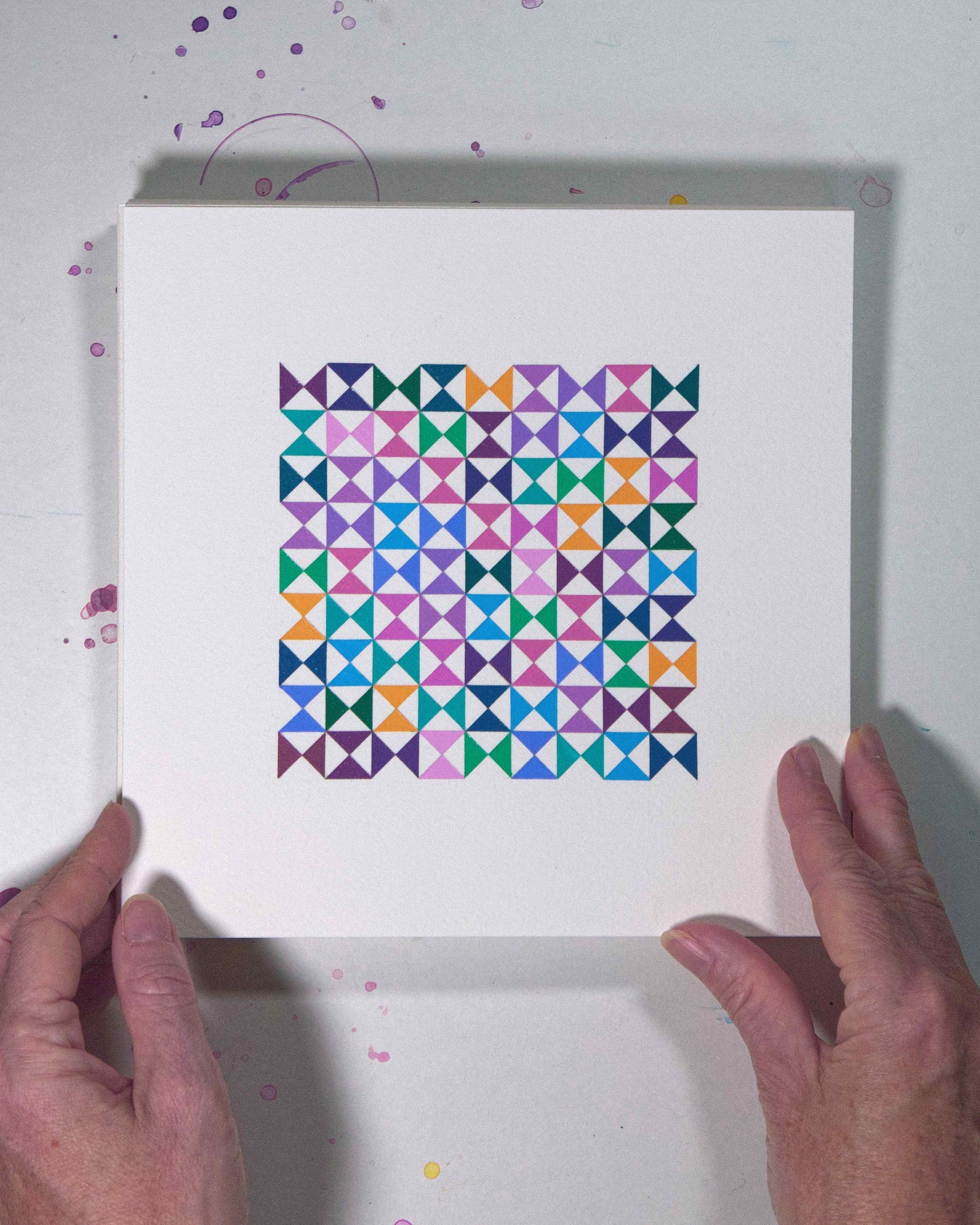 Hands holding a bold, graphic multicoloured abstract painting with repeating geometric shapes, 6 August – 037/365 (46240/365) by Victoria Mardon, 365: A Year in Colour series.