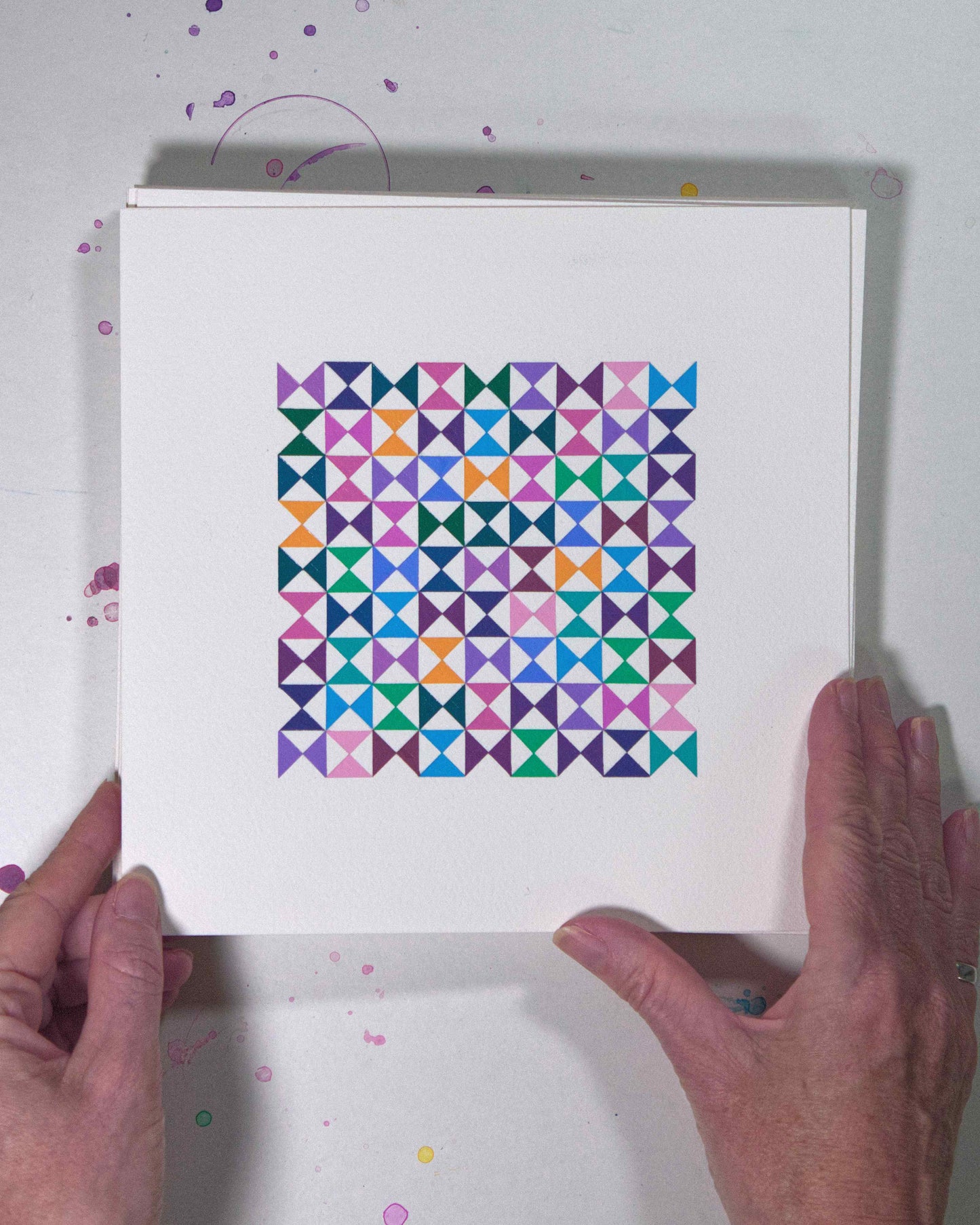 Hands holding a bold, graphic multicoloured abstract painting with repeating geometric shapes, 6 July – 006/365 (46209/365) by Victoria Mardon, 365: A Year in Colour series.