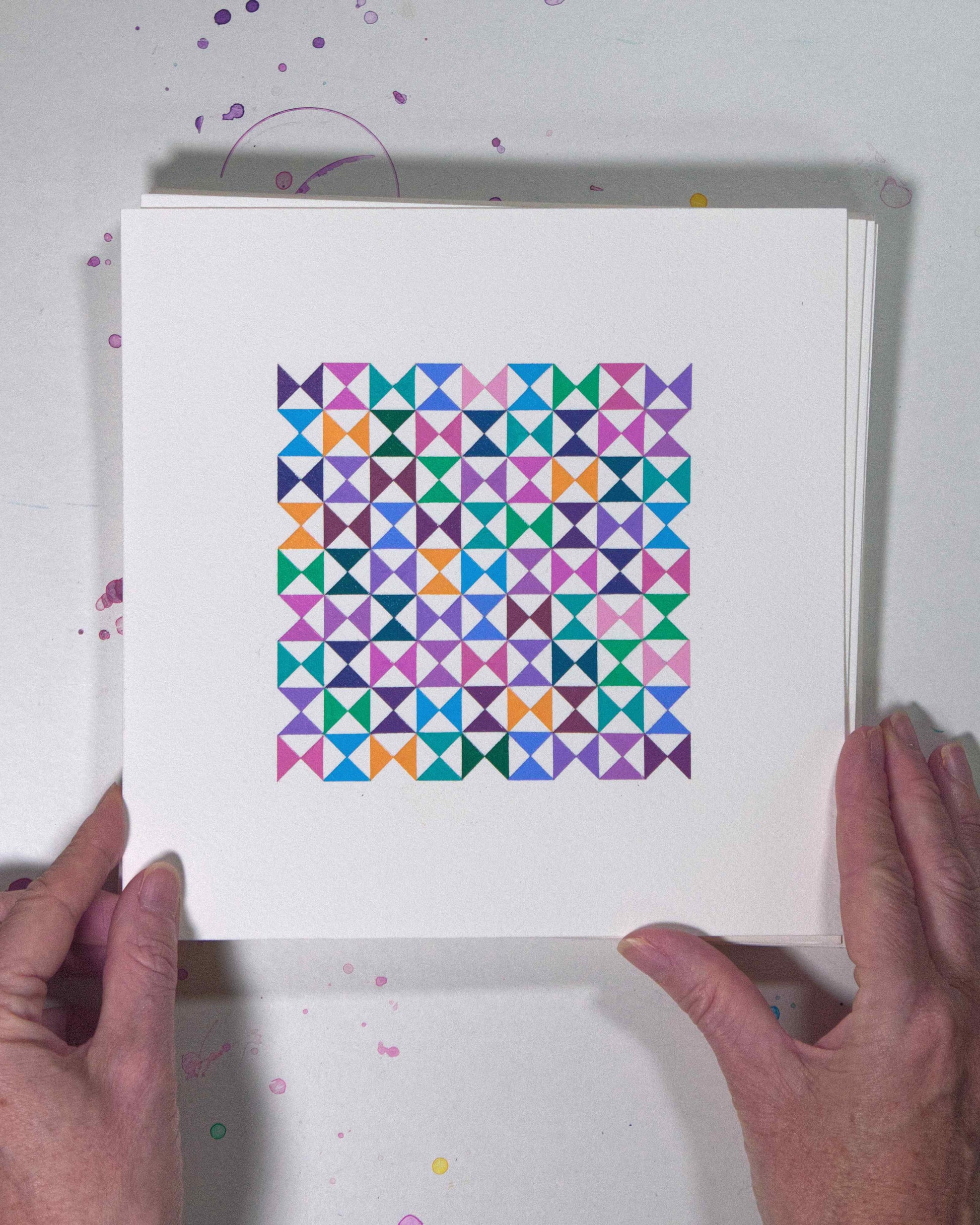Hands holding a bold, graphic multicoloured abstract painting with repeating geometric shapes, 9 July – 009/365 (46212/365) by Victoria Mardon, 365: A Year in Colour series.