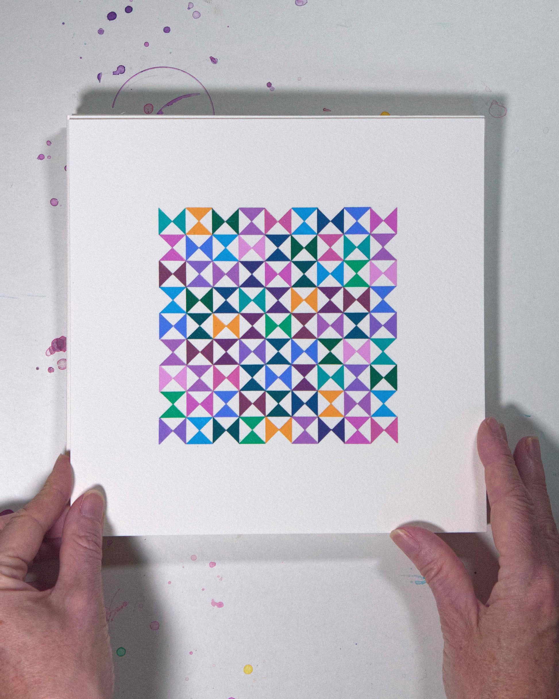 Hands holding a bold, graphic multicoloured abstract painting with repeating geometric shapes, 10 August – 041/365 (46244/365) by Victoria Mardon, 365: A Year in Colour series.