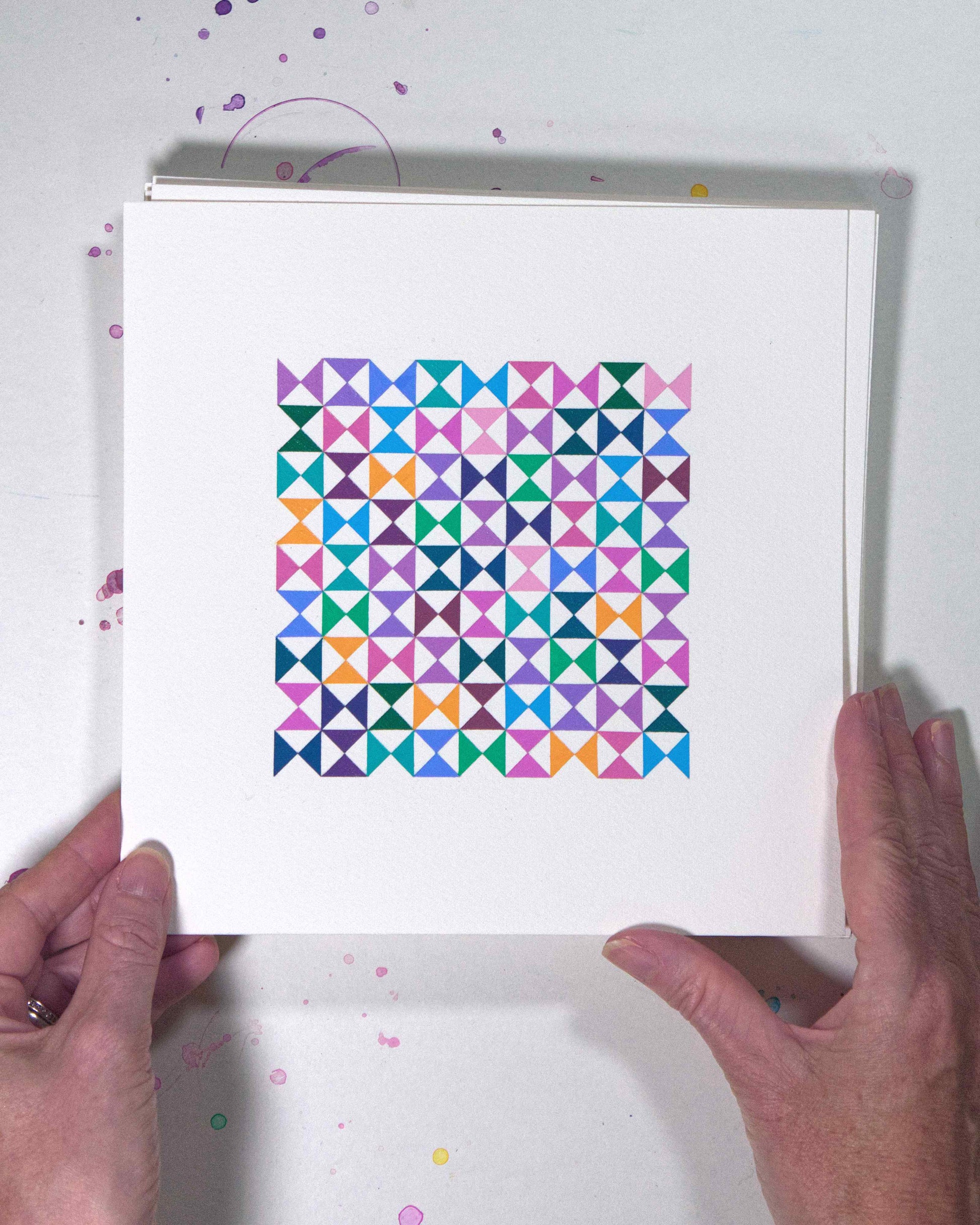 Hands holding a bold, graphic multicoloured abstract painting with repeating geometric shapes, 10 July – 010/365 (46213/365) by Victoria Mardon, 365: A Year in Colour series.