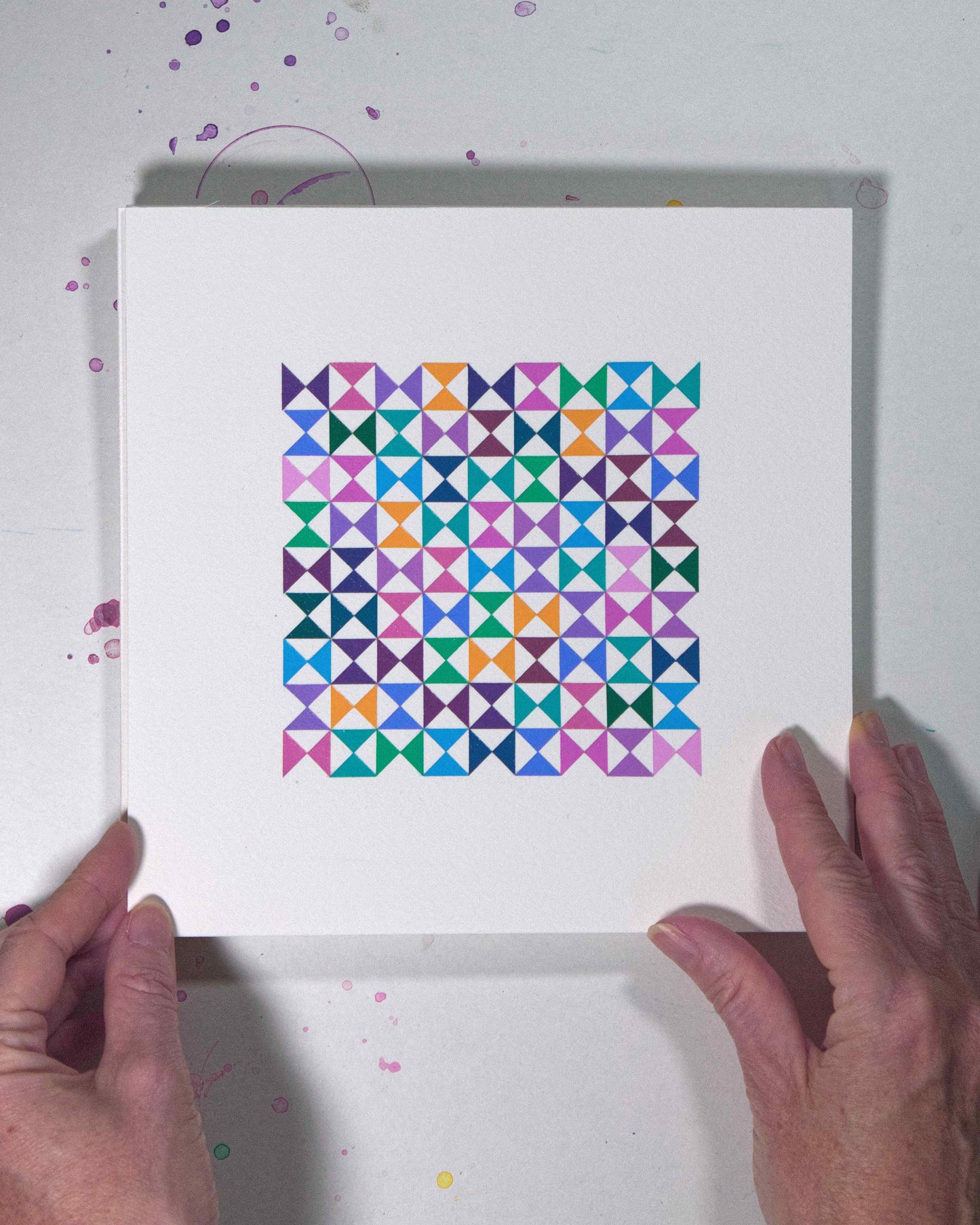 Hands holding a bold, graphic multicoloured abstract painting with repeating geometric shapes, 12 August – 043/365 (46246/365) by Victoria Mardon, 365: A Year in Colour series.
