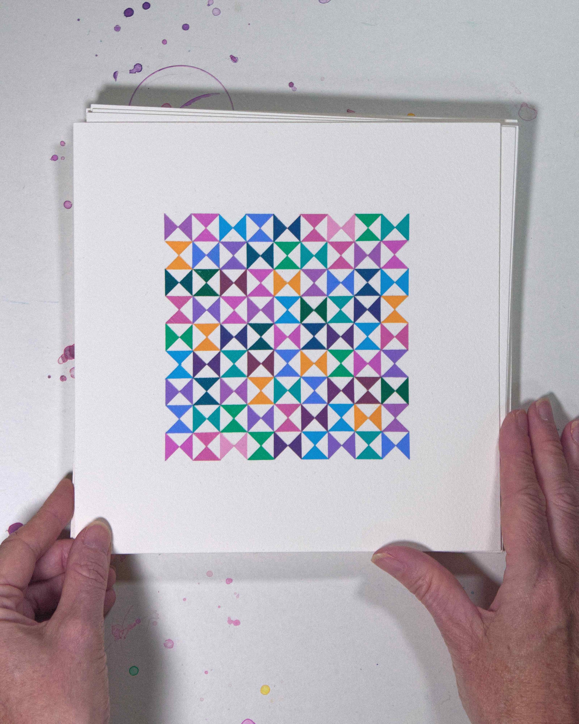Hands holding a bold, graphic multicoloured abstract painting with repeating geometric shapes, 12 July – 012/365 (46215/365) by Victoria Mardon, 365: A Year in Colour series.
