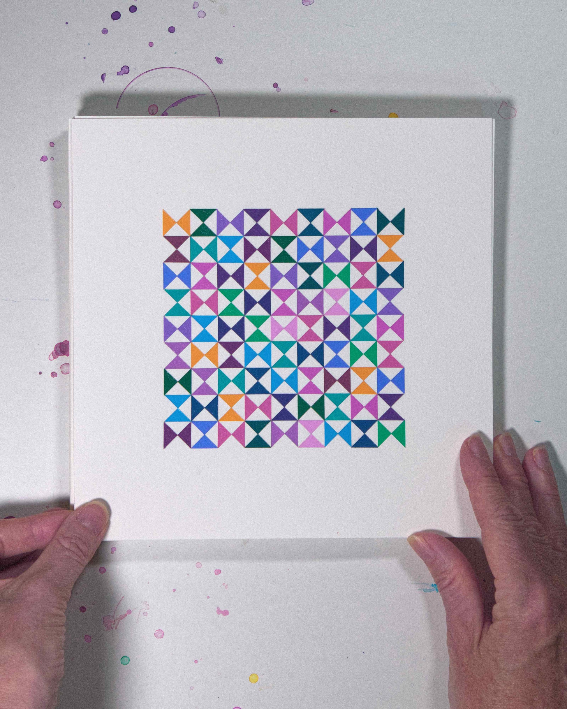 Hands holding a bold, graphic multicoloured abstract painting with repeating geometric shapes, 13 August – 044/365 (46247/365) by Victoria Mardon, 365: A Year in Colour series.