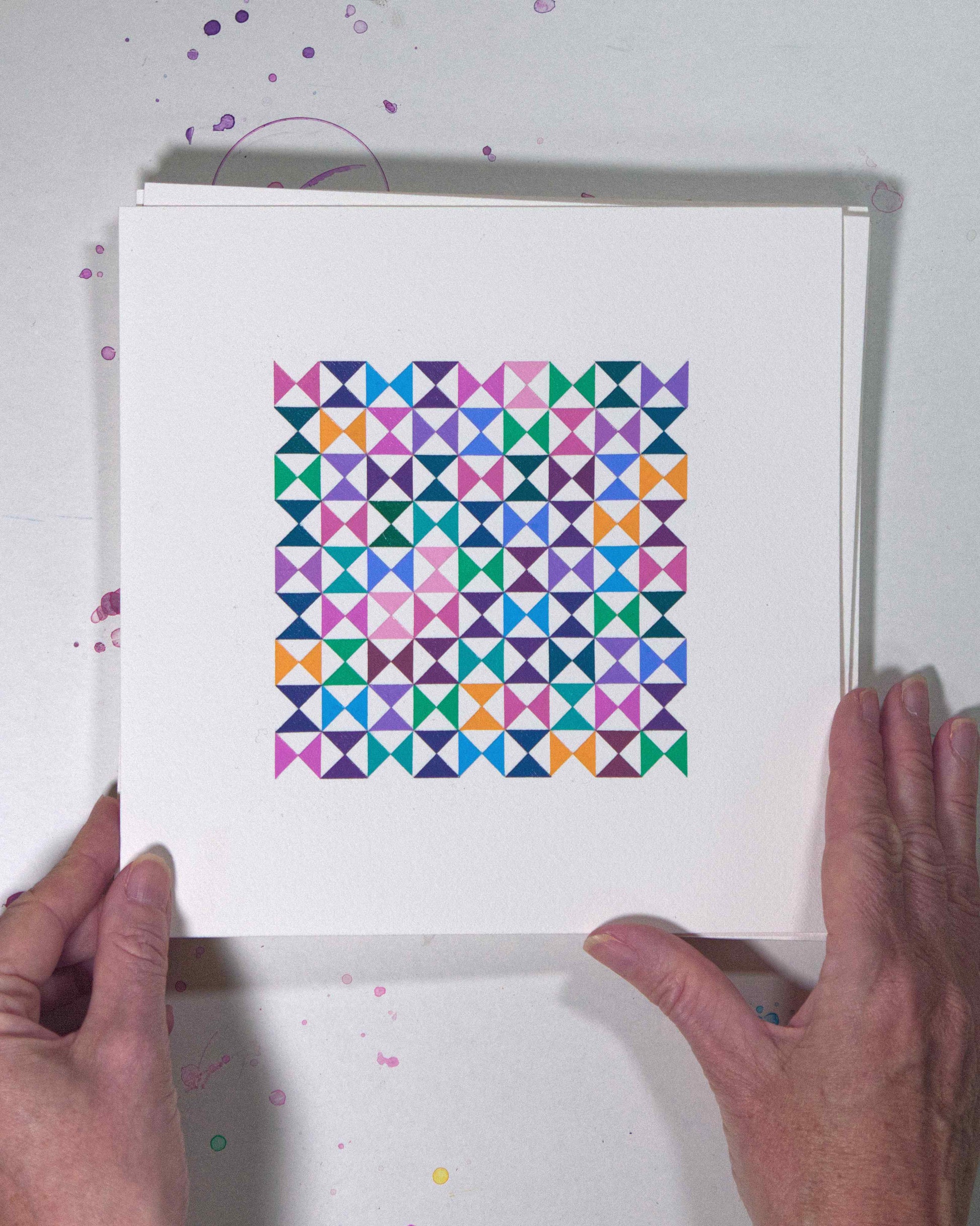 Hands holding a bold, graphic multicoloured abstract painting with repeating geometric shapes, 14 July – 014/365 (46217/365) by Victoria Mardon, 365: A Year in Colour series.