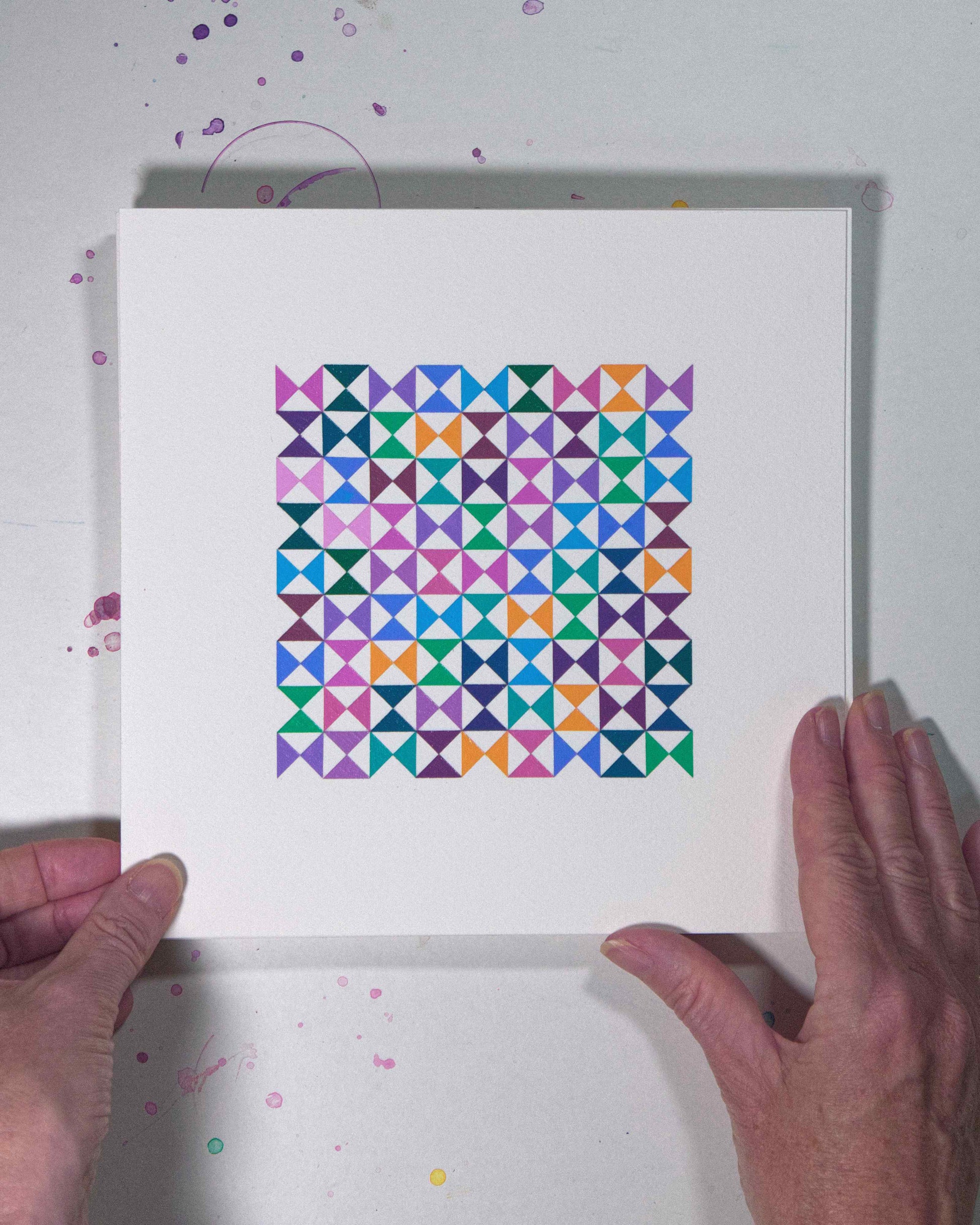 Hands holding a bold, graphic multicoloured abstract painting with repeating geometric shapes, 15 August – 046/365 (46249/365) by Victoria Mardon, 365: A Year in Colour series.