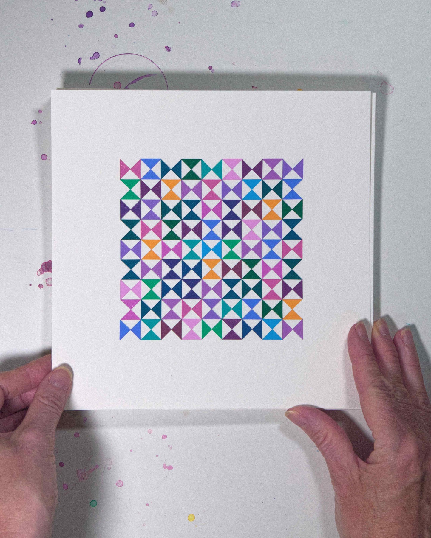 Hands holding a bold, graphic multicoloured abstract painting with repeating geometric shapes, 17 August – 048/365 (46251/365) by Victoria Mardon, 365: A Year in Colour series.