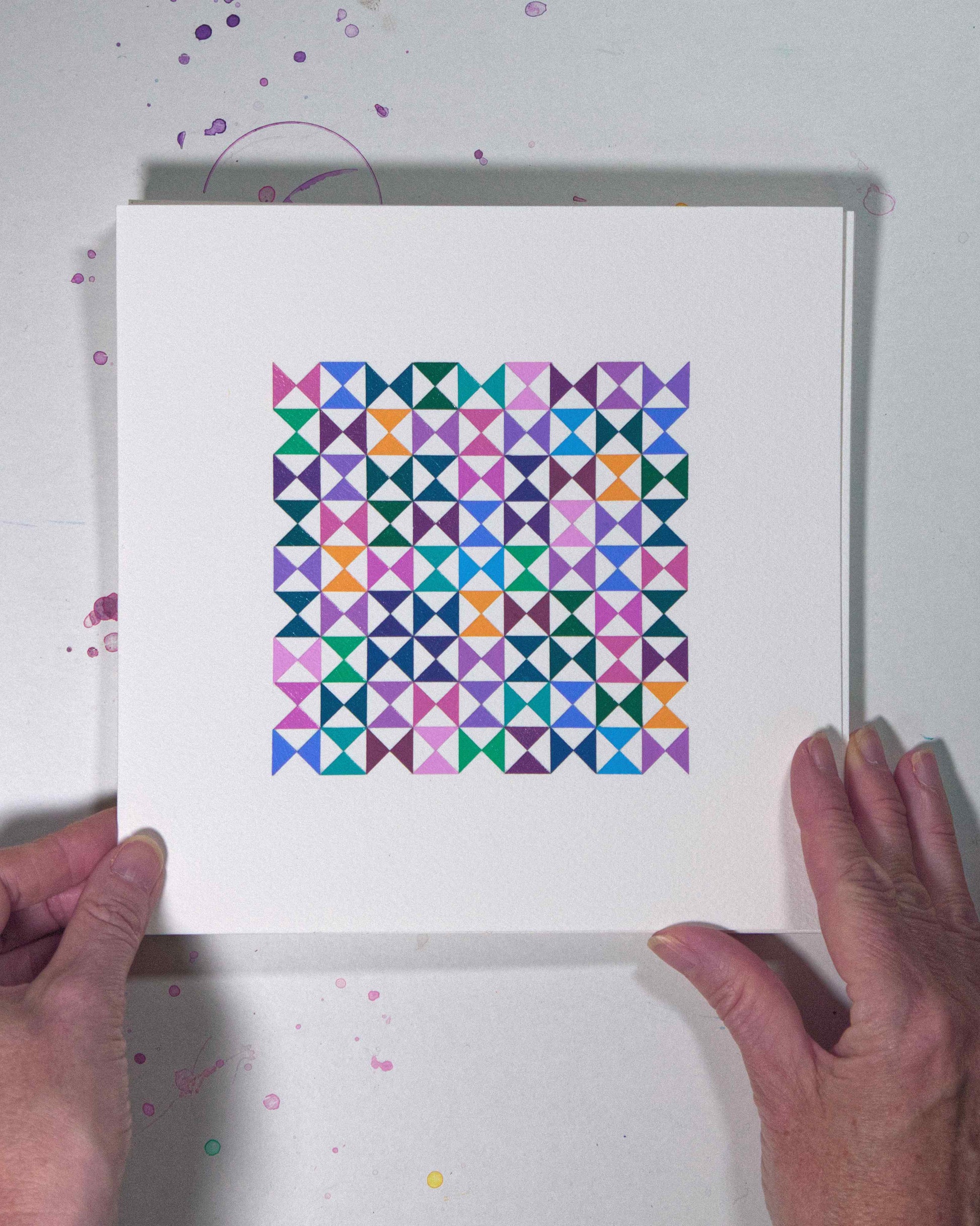 Hands holding a bold, graphic multicoloured abstract painting with repeating geometric shapes, 17 August – 048/365 (46251/365) by Victoria Mardon, 365: A Year in Colour series.