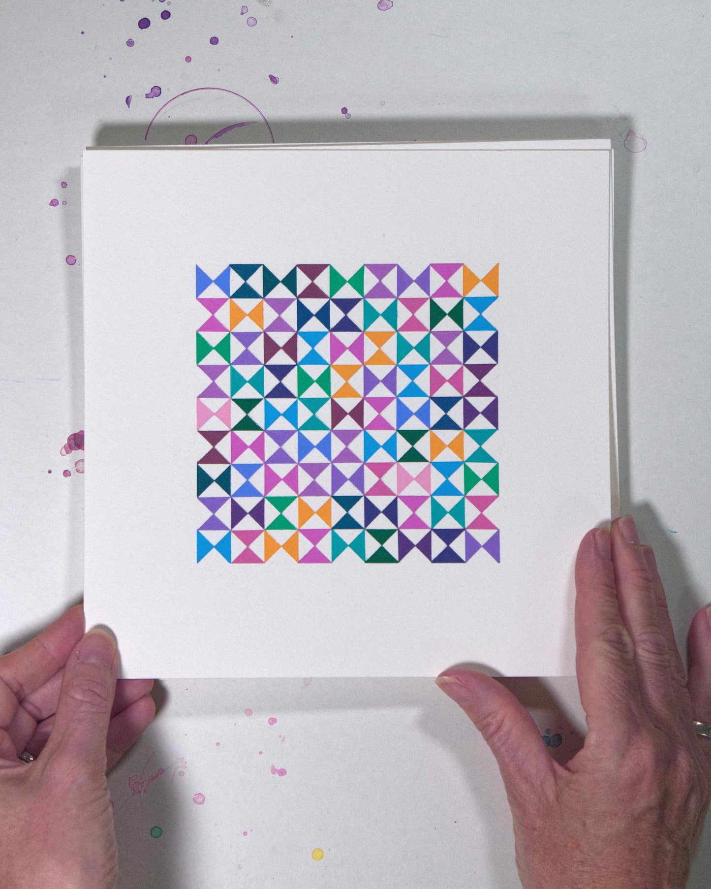 Hands holding a bold, graphic multicoloured abstract painting with repeating geometric shapes, 17 July – 017/365 (46220/365) by Victoria Mardon, 365: A Year in Colour series.