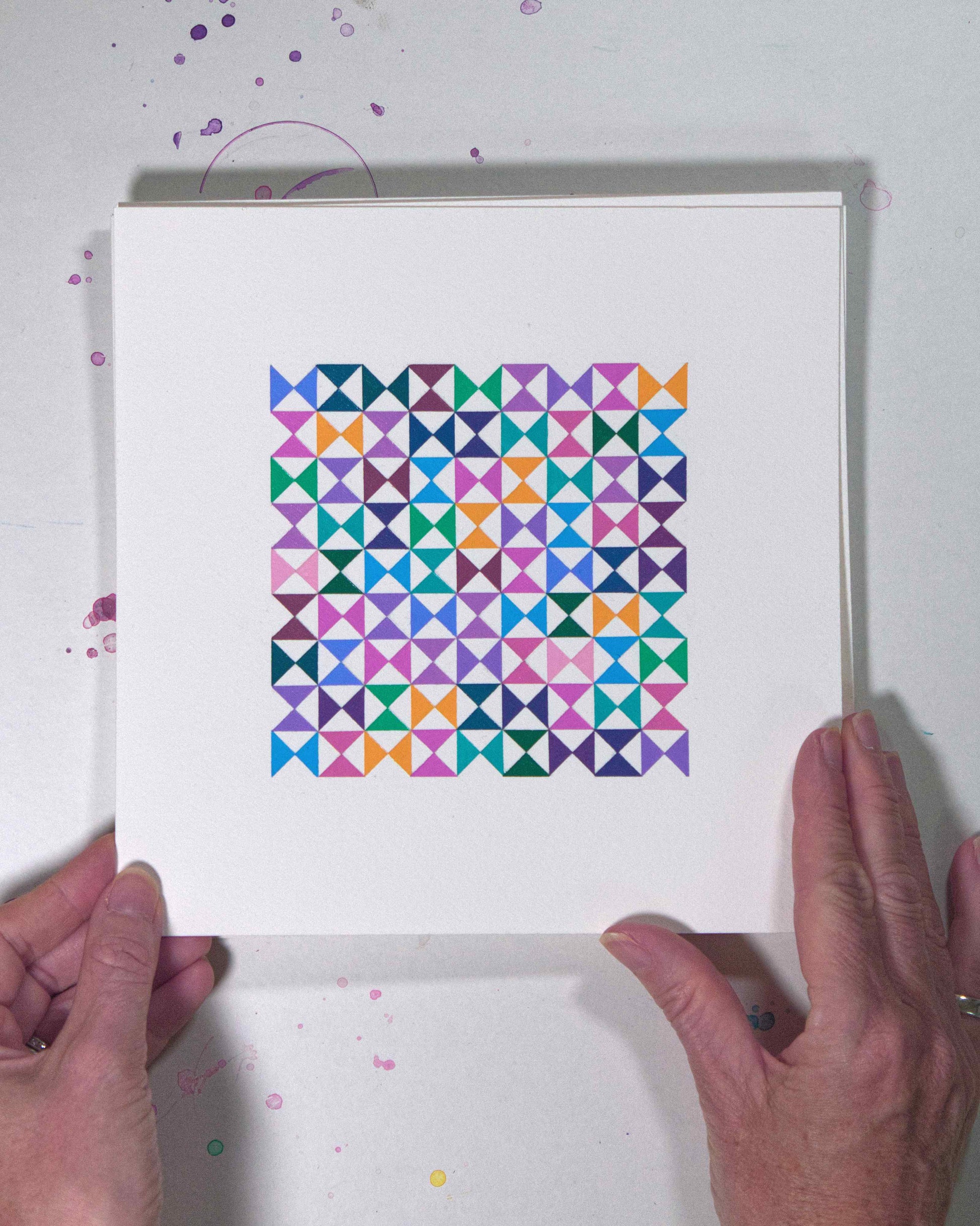 Hands holding a bold, graphic multicoloured abstract painting with repeating geometric shapes, 17 July – 017/365 (46220/365) by Victoria Mardon, 365: A Year in Colour series.