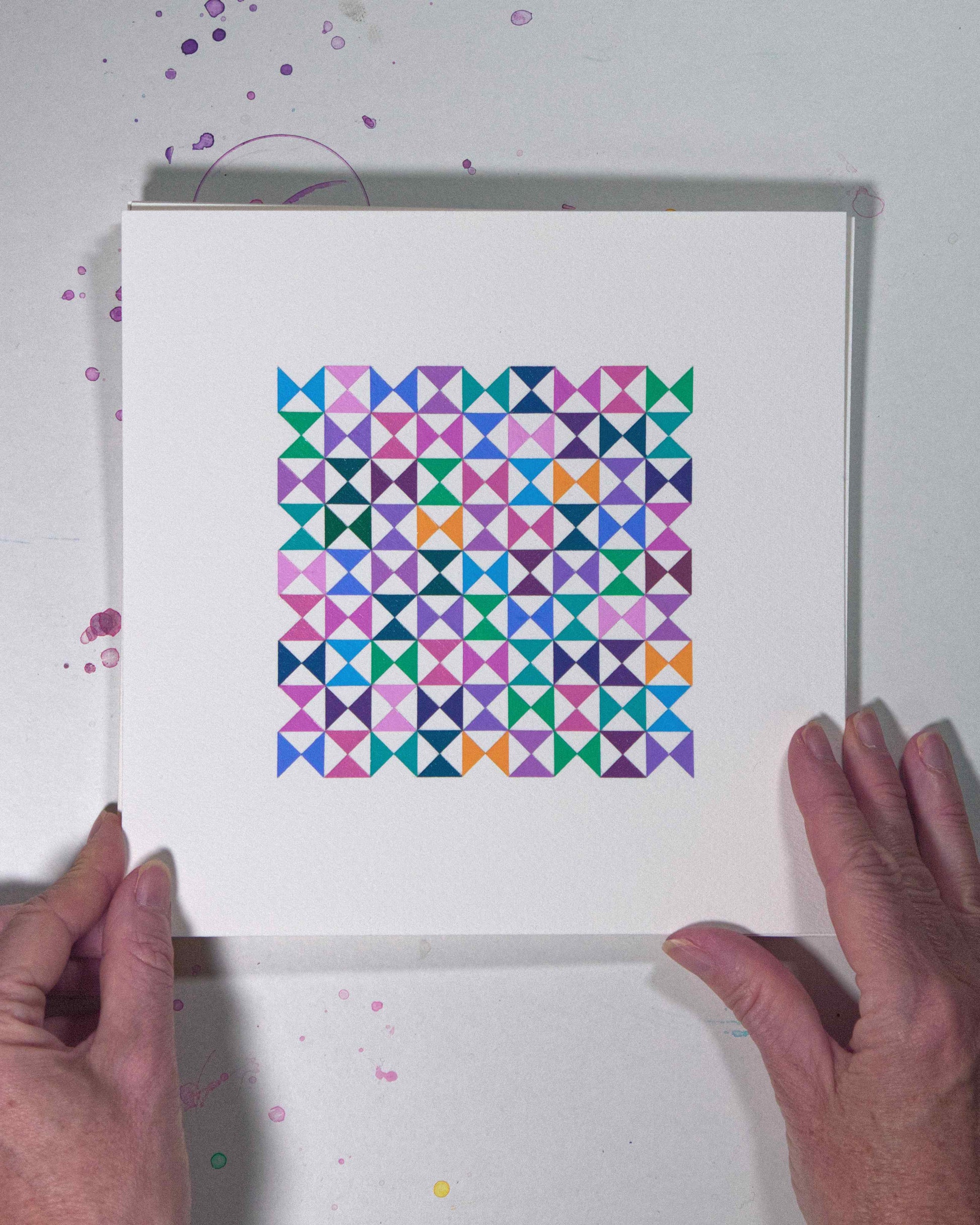 Hands holding a bold, graphic multicoloured abstract painting with repeating geometric shapes, 19 August – 050/365 (46253/365) by Victoria Mardon, 365: A Year in Colour series.