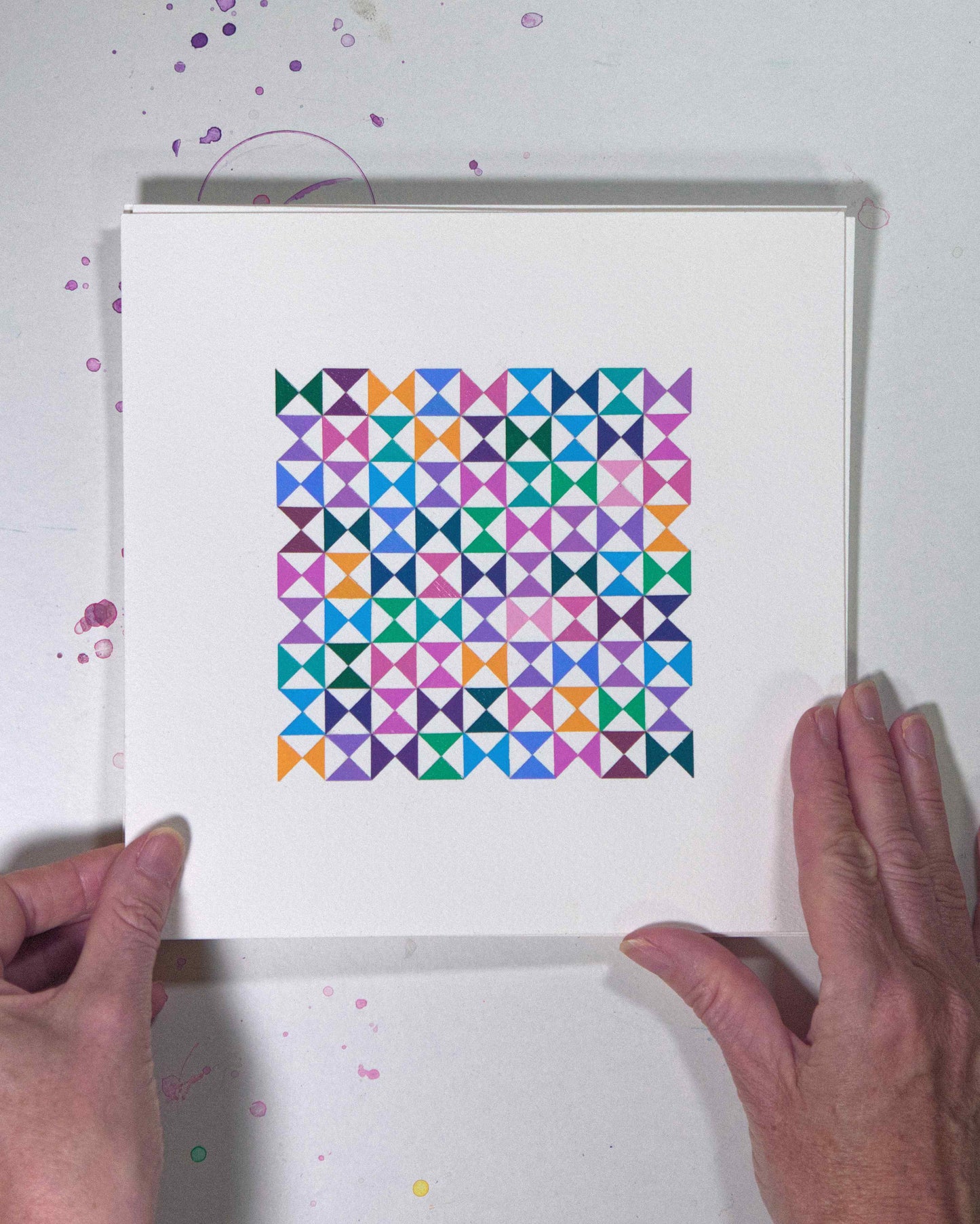 Hands holding a bold, graphic multicoloured abstract painting with repeating geometric shapes, 22 July – 022/365 (46225/365) by Victoria Mardon, 365: A Year in Colour series.