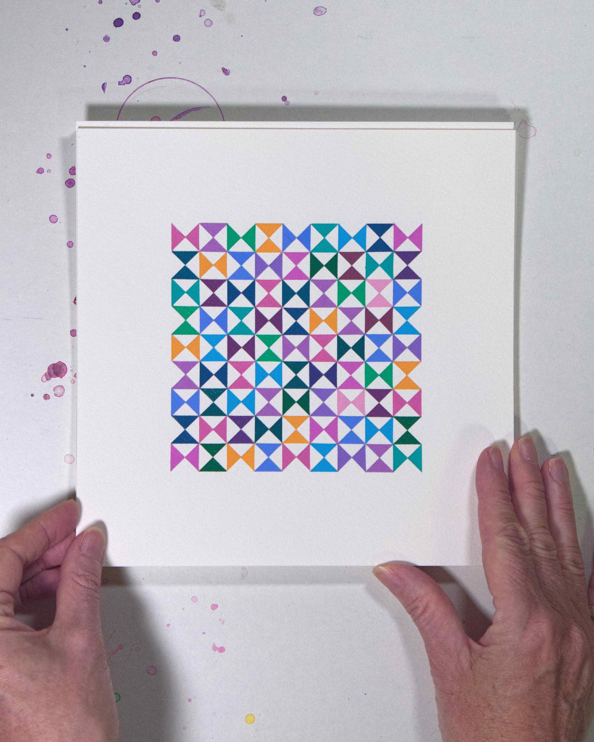 Hands holding a bold, graphic multicoloured abstract painting with repeating geometric shapes, 24 July – 024/365 (46227/365) by Victoria Mardon, 365: A Year in Colour series.