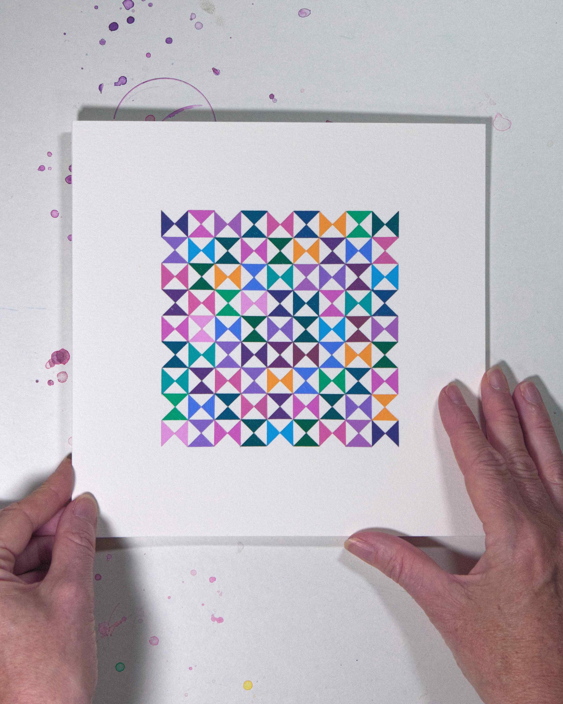 Hands holding a bold, graphic multicoloured abstract painting with repeating geometric shapes, 25 August – 056/365 (46259/365) by Victoria Mardon, 365: A Year in Colour series.
