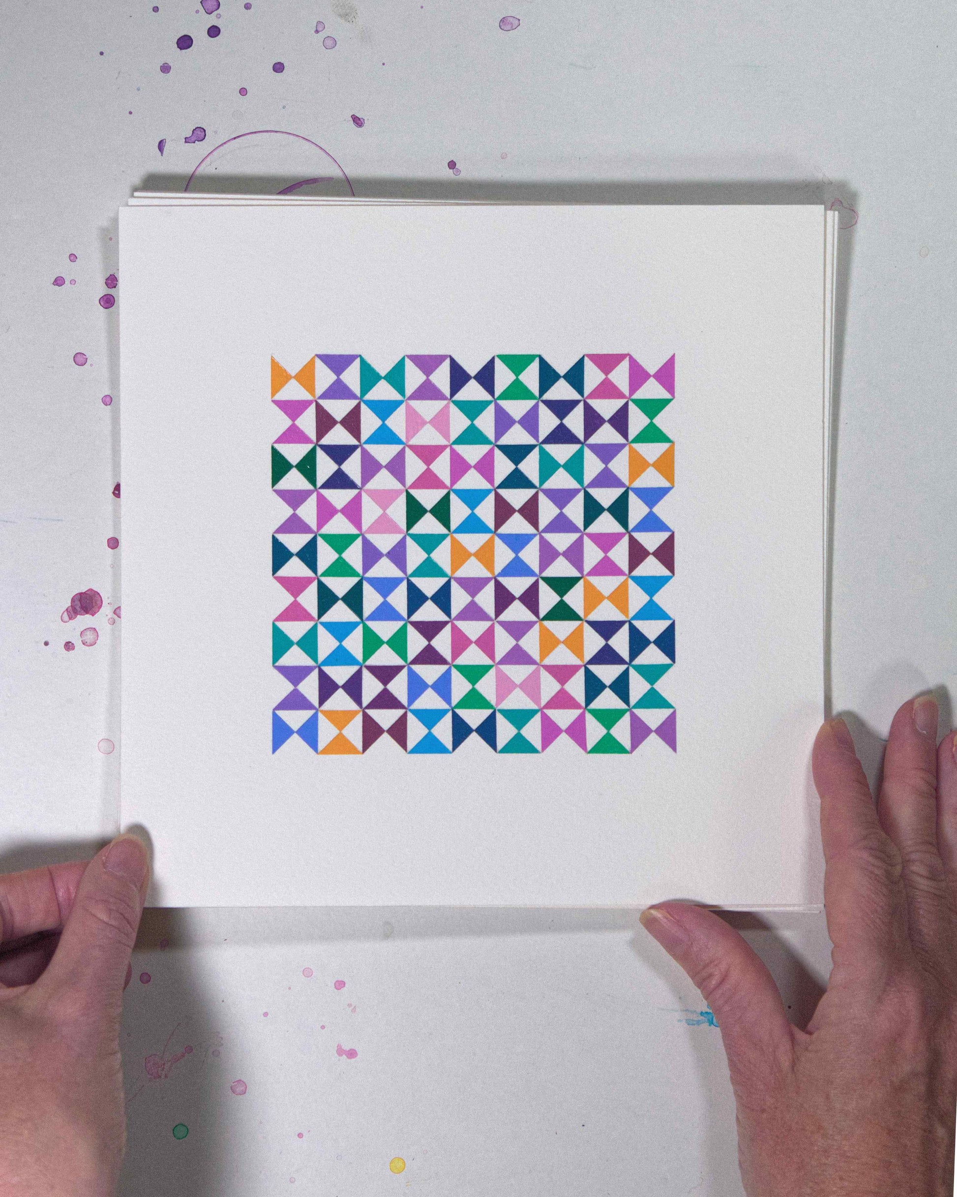 Hands holding a bold, graphic multicoloured abstract painting with repeating geometric shapes, 25 July – 025/365 (46228/365) by Victoria Mardon, 365: A Year in Colour series.