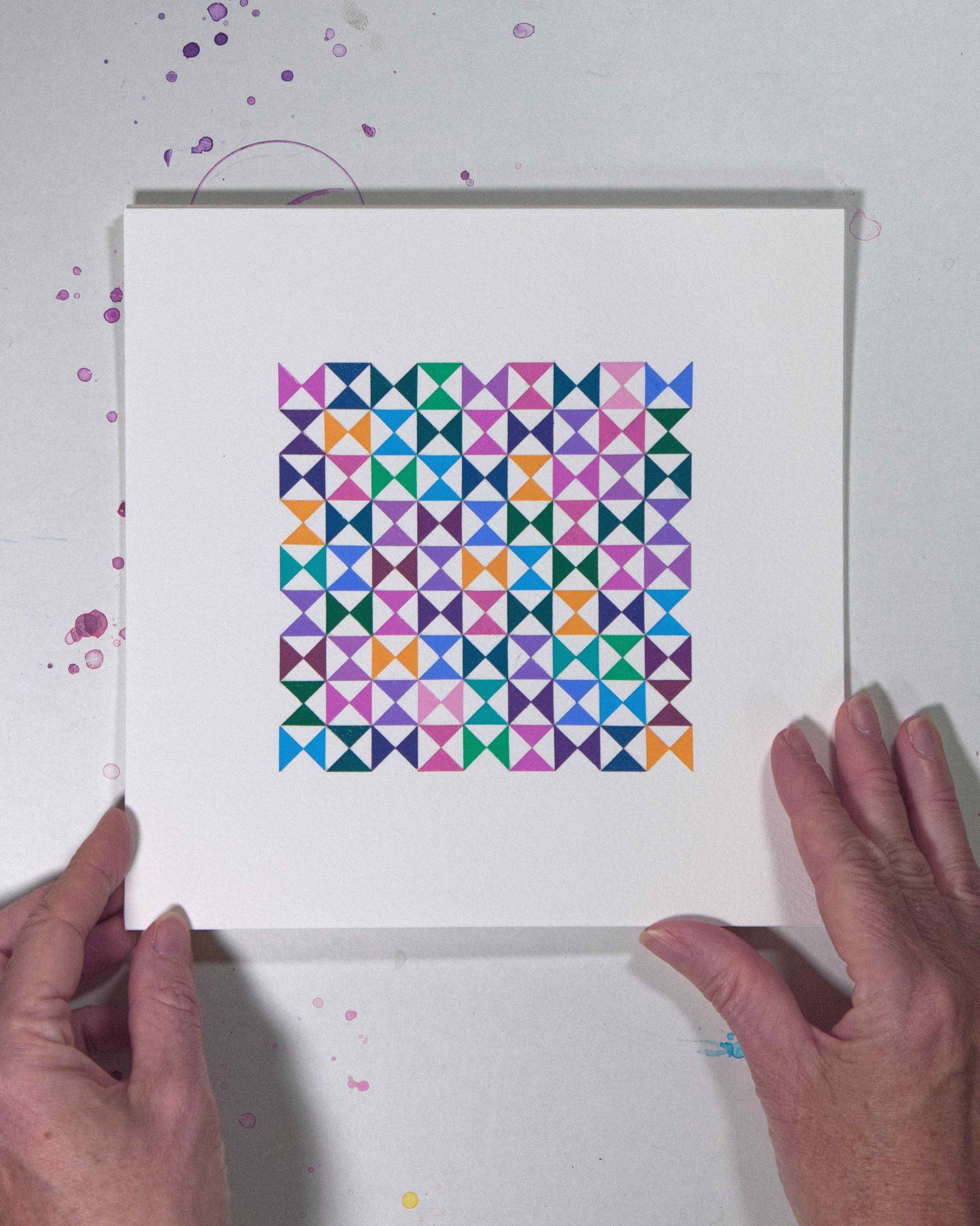 Hands holding a bold, graphic multicoloured abstract painting with repeating geometric shapes, 27 July – 027/365 by Victoria Mardon, 365: A Year in Colour series.