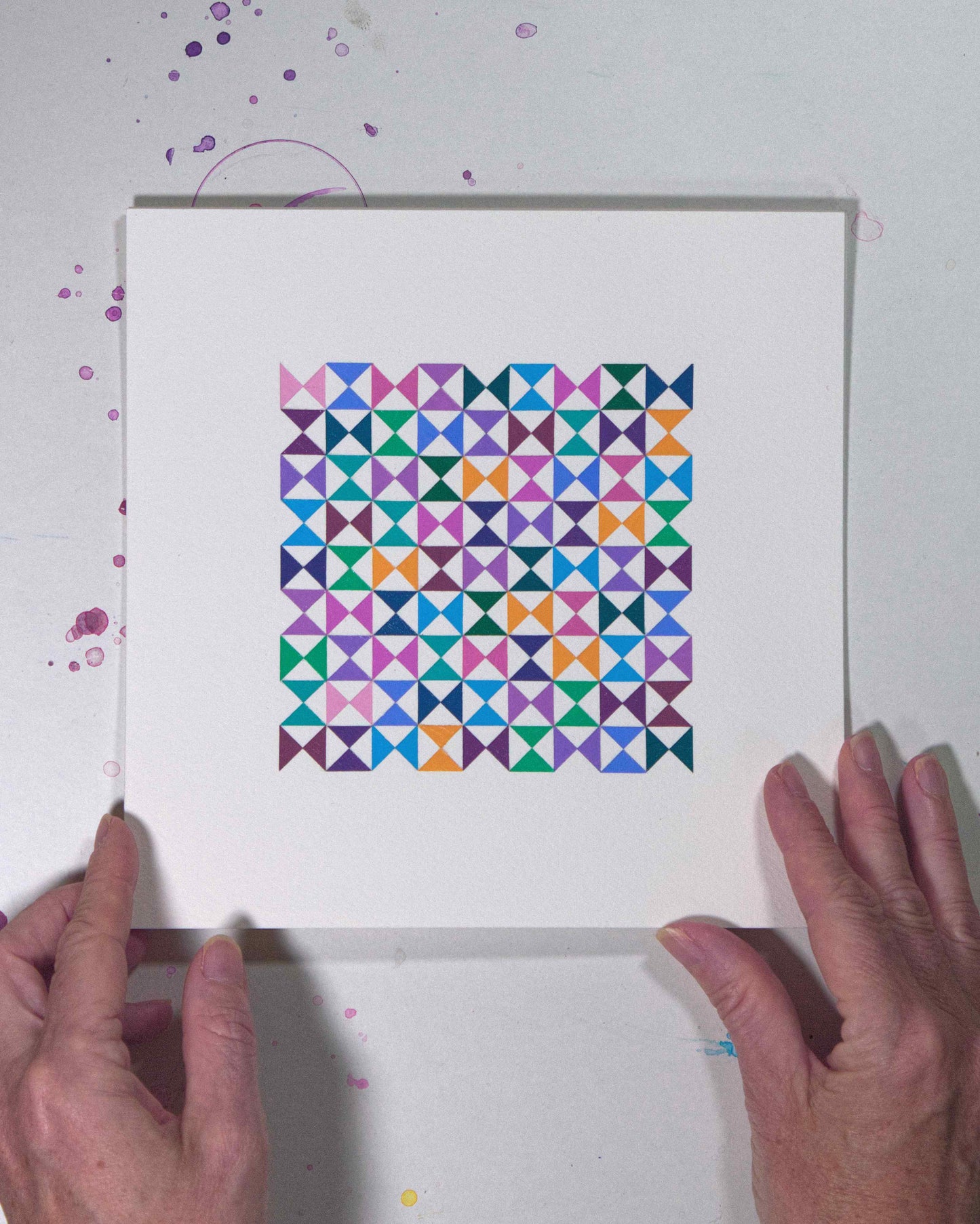 Hands holding a bold, graphic multicoloured abstract painting with repeating geometric shapes, 28 July – 028/365 by Victoria Mardon, 365: A Year in Colour series.
